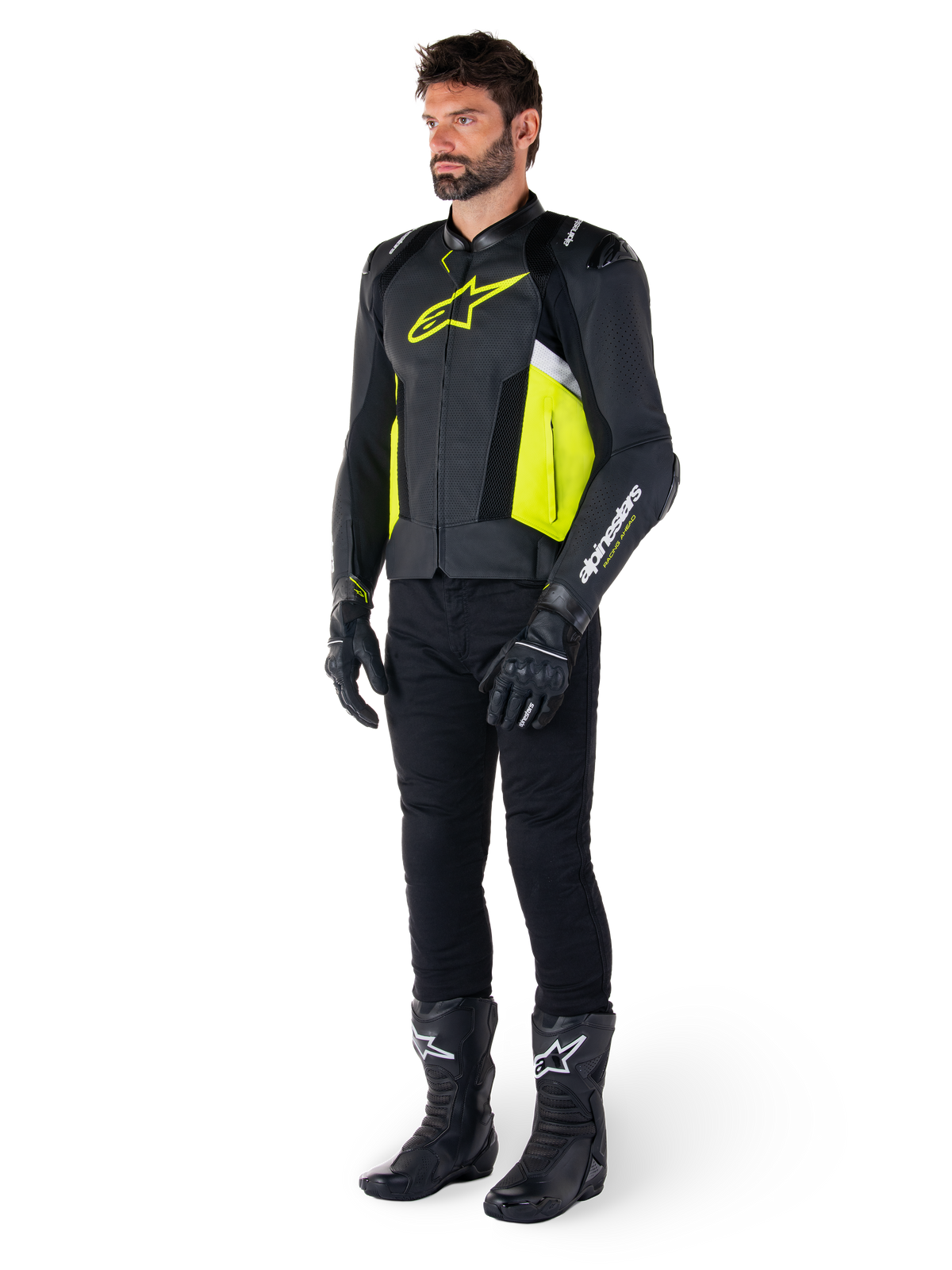 Männliches Model in der Alpinestars Missile V3 Airflow Lederjacke in Schwarz, Gelb Fluo und Weiß, kombiniert mit schwarzen Motorradhandschuhen, Hose und Stiefeln, zeigt das perforierte Lederdesign und die vom Rennsport inspirierte Ästhetik.