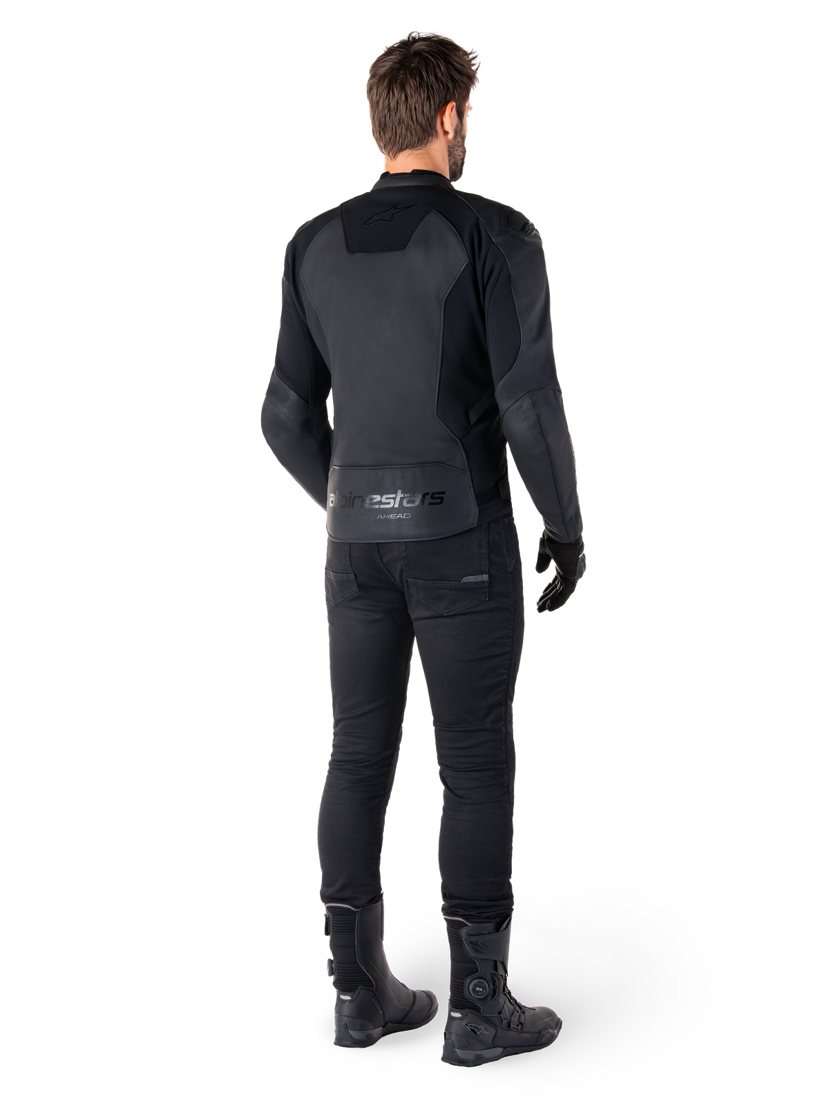 Alpinestars Faster V3 Lederjacke, Schwarz Schwarz, Rückansicht eines Fahrers, mit hochwertigen Lederpaneelen und geprägtem Alpinestars-Branding, kombiniert mit schwarzer Motorradhose und Stiefeln für einen kompletten Sport-Motorrad-Look.
