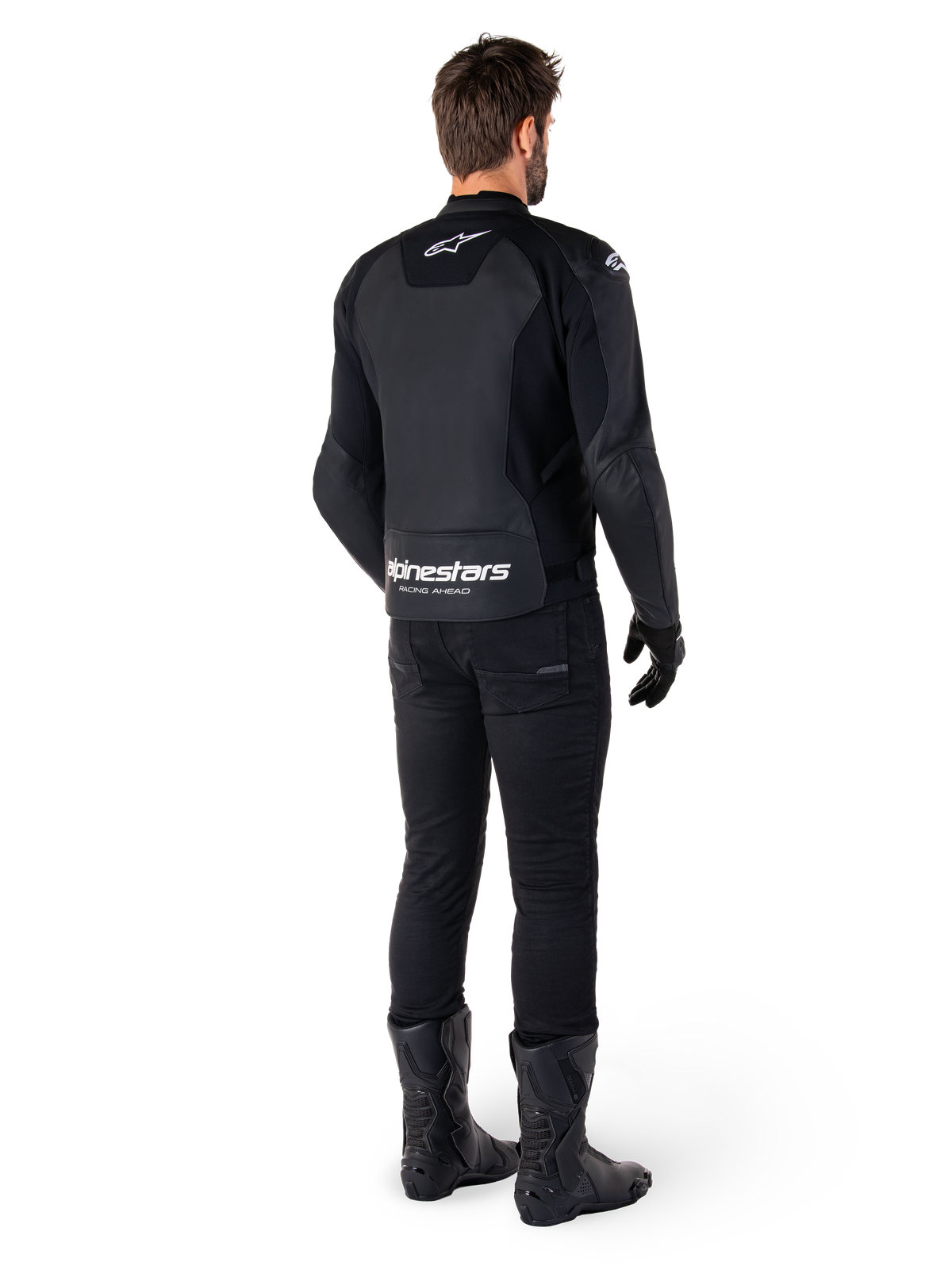 Alpinestars Faster V3 Lederjacke, Rückansicht, Schwarz und Weiß, mit „alpinestars RACING AHEAD“-Branding am unteren Rücken, getragen mit schwarzer Motorradhose und Stiefeln, sportlich inspirierte Motorrad-Lederjacke mit Stretcheinsätzen.