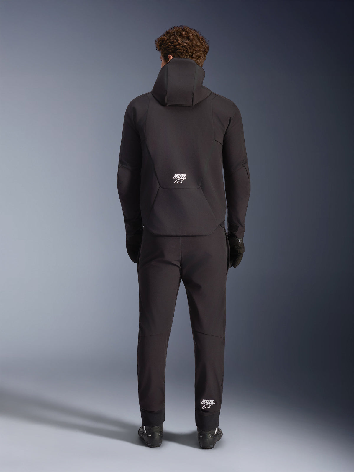 Alpinestars Aeroshell Waterproof Jacket, black men's motorcycle softshell hoodie, back view with white ASTARS logo.