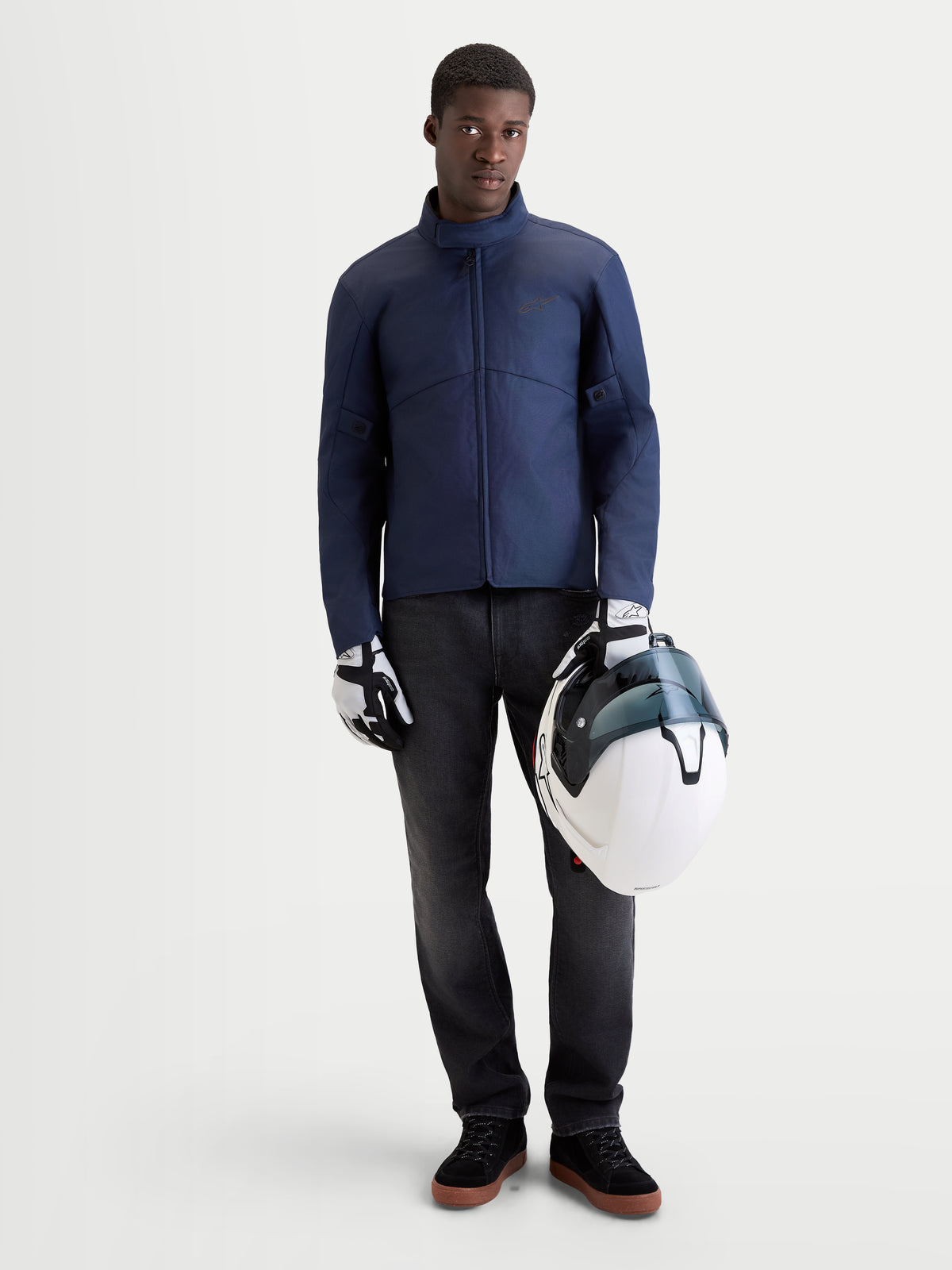 Alpinestars C-1 Waterproof Jacke, urbane Motorrad-Textiljacke für Herren in Dunkelblauen, Vorderansicht an einem Model mit passenden Handschuhen und einem weißen Helm, wasserdichte Schutzkleidung für kalte und nassen Bedingungen