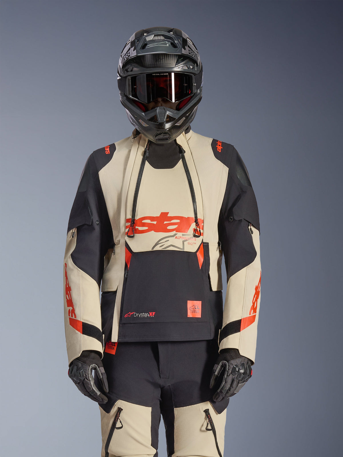 Alpinestars Halo Pro Drystar XF Laminierte Jacke, Adventure-Motorradjacke in Mastic Black und Beige mit roten Akzenten, getragen mit kompletter Schutzausrüstung inklusive Helm und Handschuhen, mit modularen Belüftungspaneelen und 3L-Laminatkonstruktion