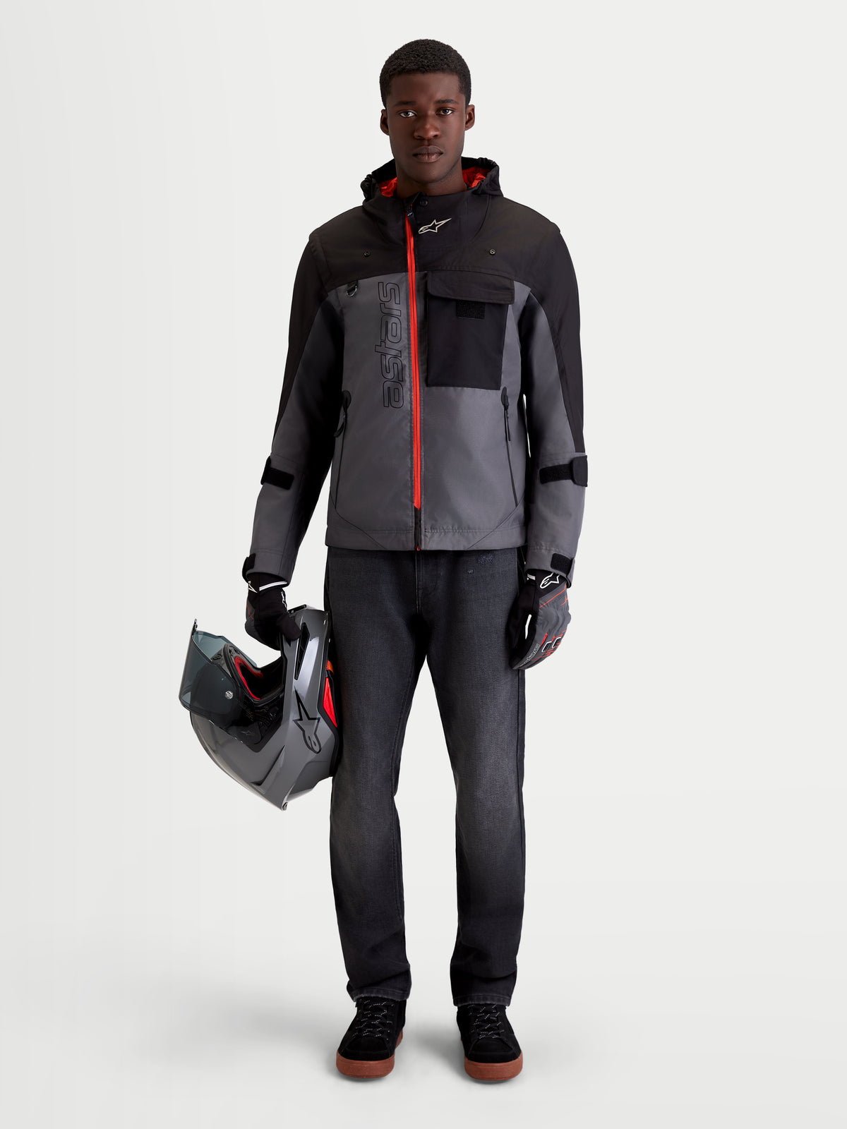 Alpinestars Morfex Parka WP Jacke, urbane Motorradjacke für Herren in Mondgrau und Schwarz, Vorderansicht an einem Model, das die Jacke trägt und einen Helm hält