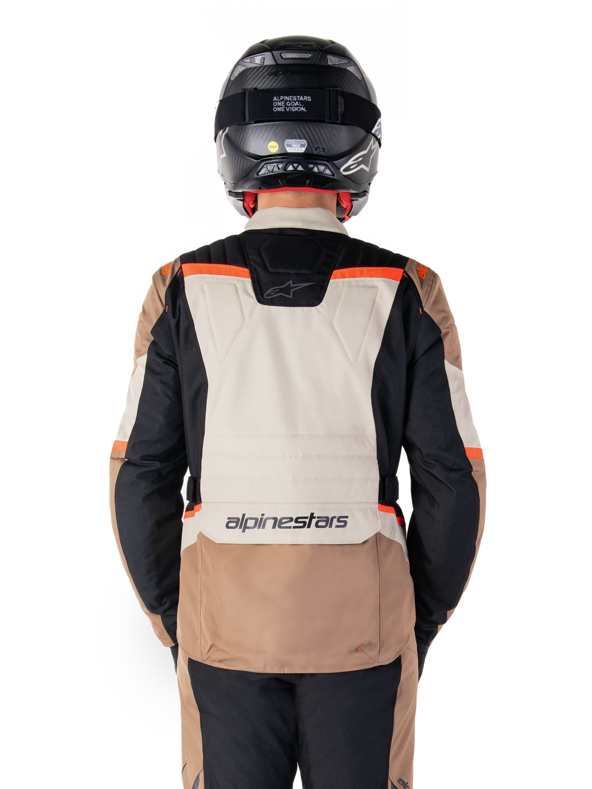 Alpinestars ST-1 Waterproof Jacket, Dark Khaki Sand Black Red Fluo, Rückansicht, Adventure-Touring-Motorradjacke mit einem großen sandfarbenen Rückeneinsatz, schwarzen Ärmeln und leuchtend roten Akzenten, gezeigt an einem Fahrer mit schwarzem Helm.