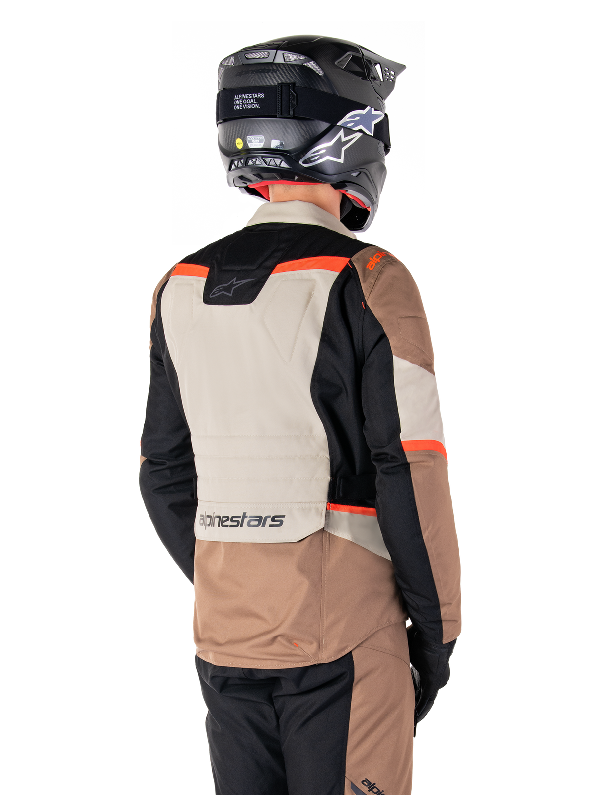 Alpinestars ST-1 Waterproof Jacke, Adventure-Touring-Jacke, Dark Khaki Sand Black Red Fluo, Rückansicht mit Textilpaneelen im Color-Block-Design, fluoreszierend roten Akzenten und Alpinestars-Branding am unteren Rücken, getragen von einem Fahrer mit schwarzem Helm.