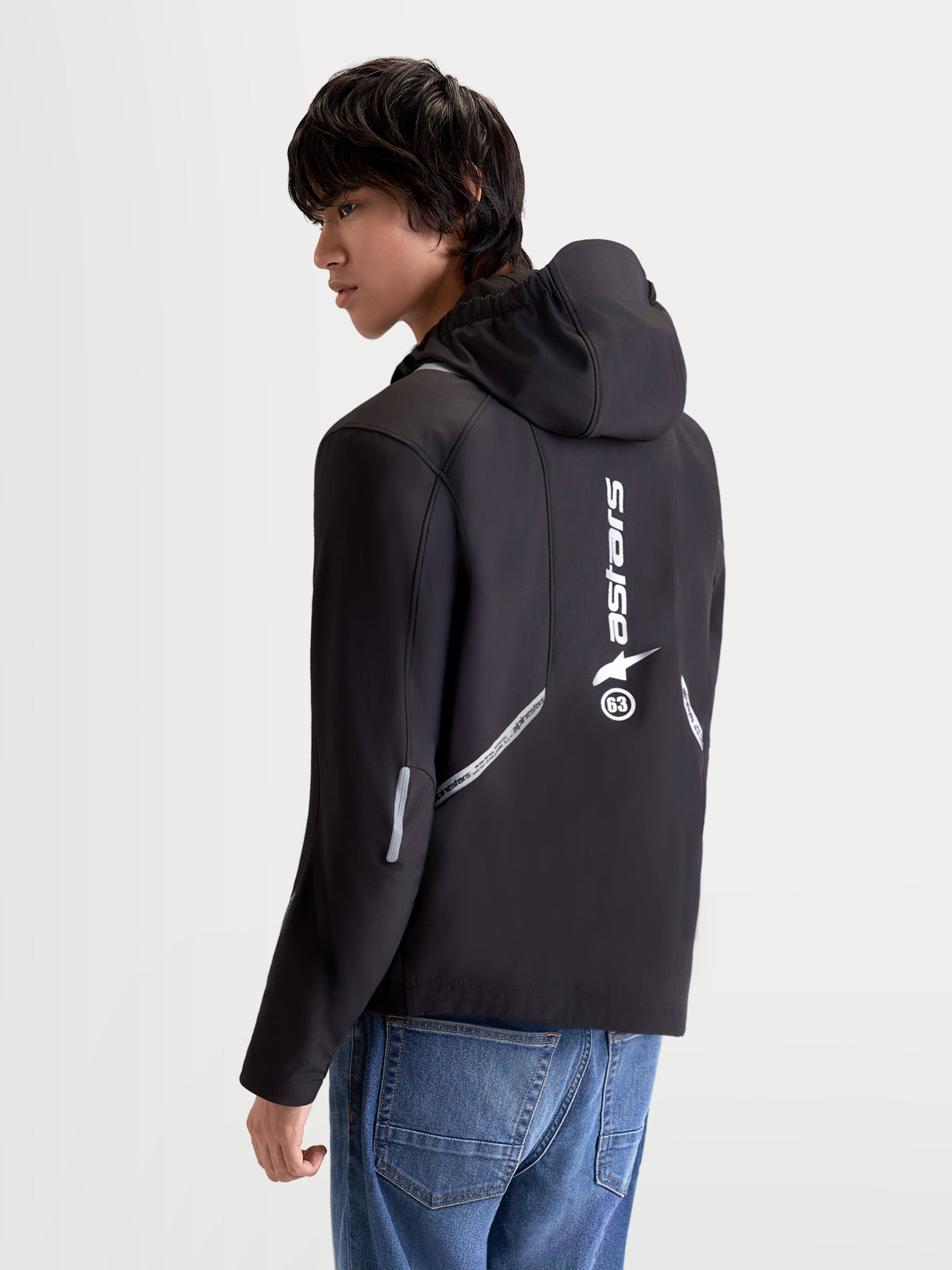 Alpinestars C 5 Drystar Jacke, urbane moderne Herren-Motorradjacke aus Textil in Schwarz, Rückansicht an einem Model mit integrierter Kapuze, reflektierenden Details und vertikalem Logo-Druck auf dem Rücken
