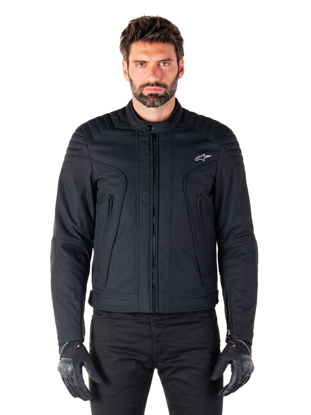 Alpinestars Clayton WR Jacke, schwarze Motorradjacke, von einem Model getragen, mit gesteppten Schulterdetails und technischen Grafiken, zentraler Vislon-Reißverschluss, vertikale Reißverschlusstaschen, kleines weißes Logo auf der Brust, urbane Fahrerausrüstung für den Straßengebrauch