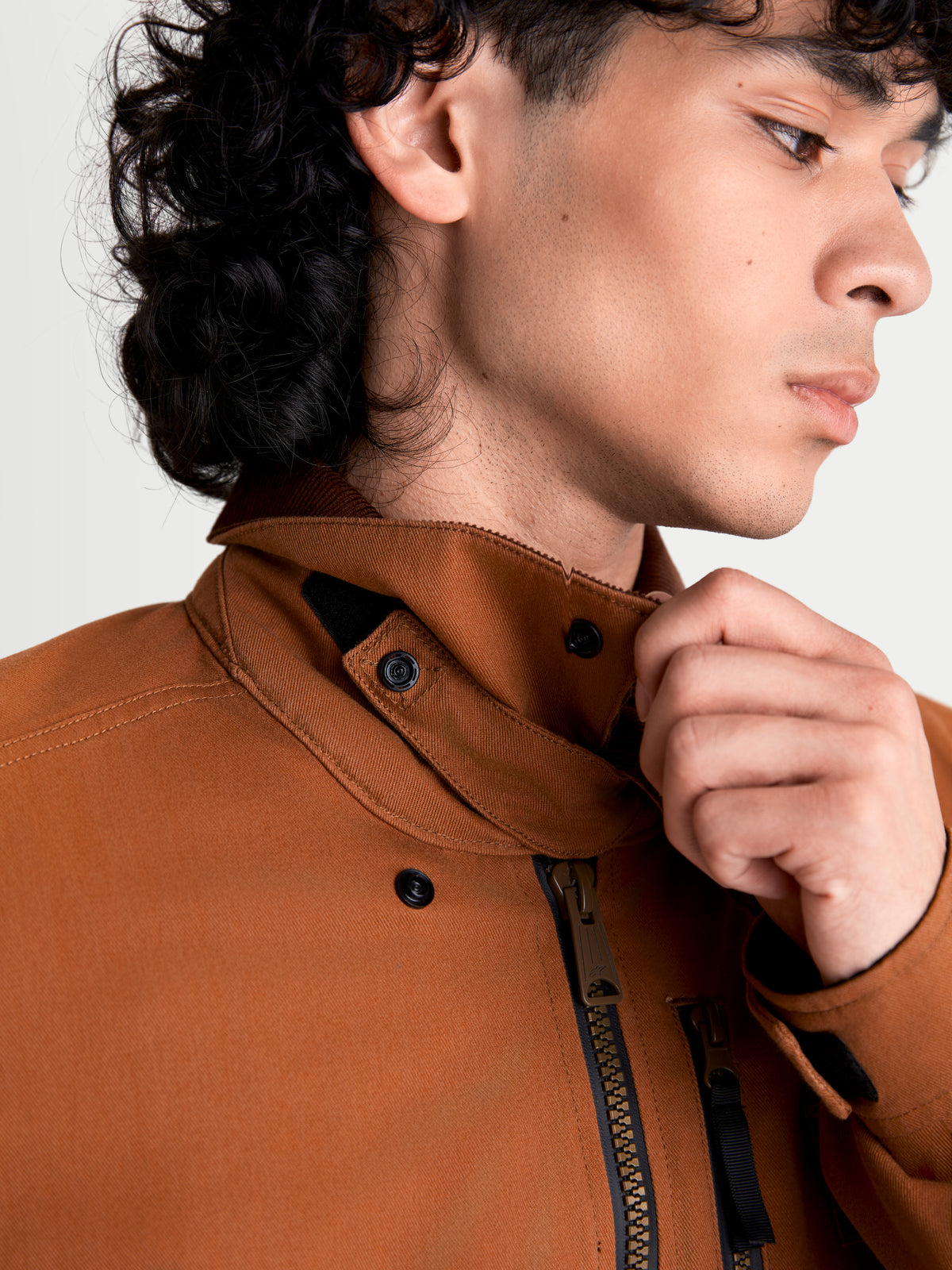 Alpinestars Mustang Wp Jacke, urbane Herren-Motorradjacke in Rostbraun und Dunkelbraun, Nahaufnahme des Kragens und des Frontreißverschlusses an einem Model