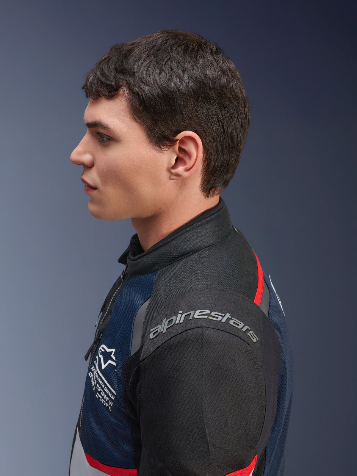 Alpinestars Andes Air Drystar® Jacke, Farbvariante Deep Blue Black Ice Gray, Seitenprofil eines männlichen Models in der Mesh-Textiljacke, mit Alpinestars-Branding auf der Schulter und roten Akzenten, Tourenbekleidung für zwei Jahreszeiten