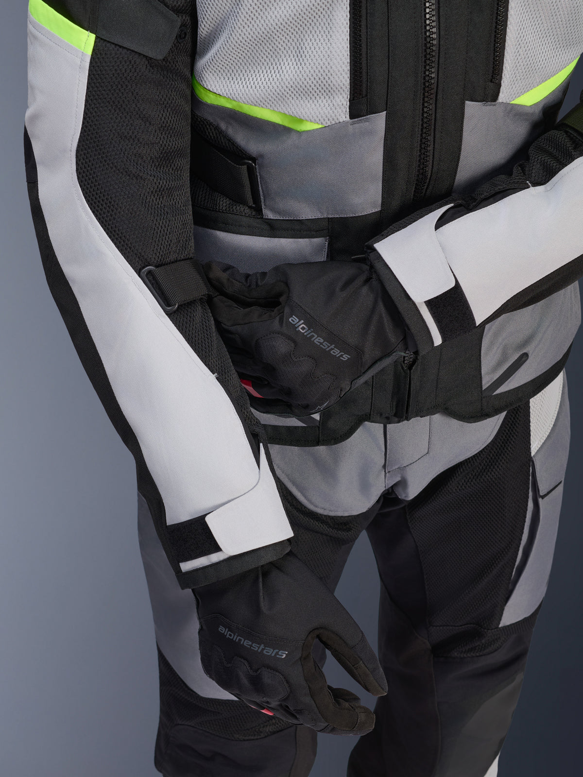 Alpinestars Andes Air Drystar® Jacke, Motorrad-Tourenjacke, Ice Gray und Dark Gray mit neongelben Akzenten, Nahaufnahme mit Mesh-Einsätzen und Verstellriemen, getragen mit schwarzen Alpinestars Handschuhen