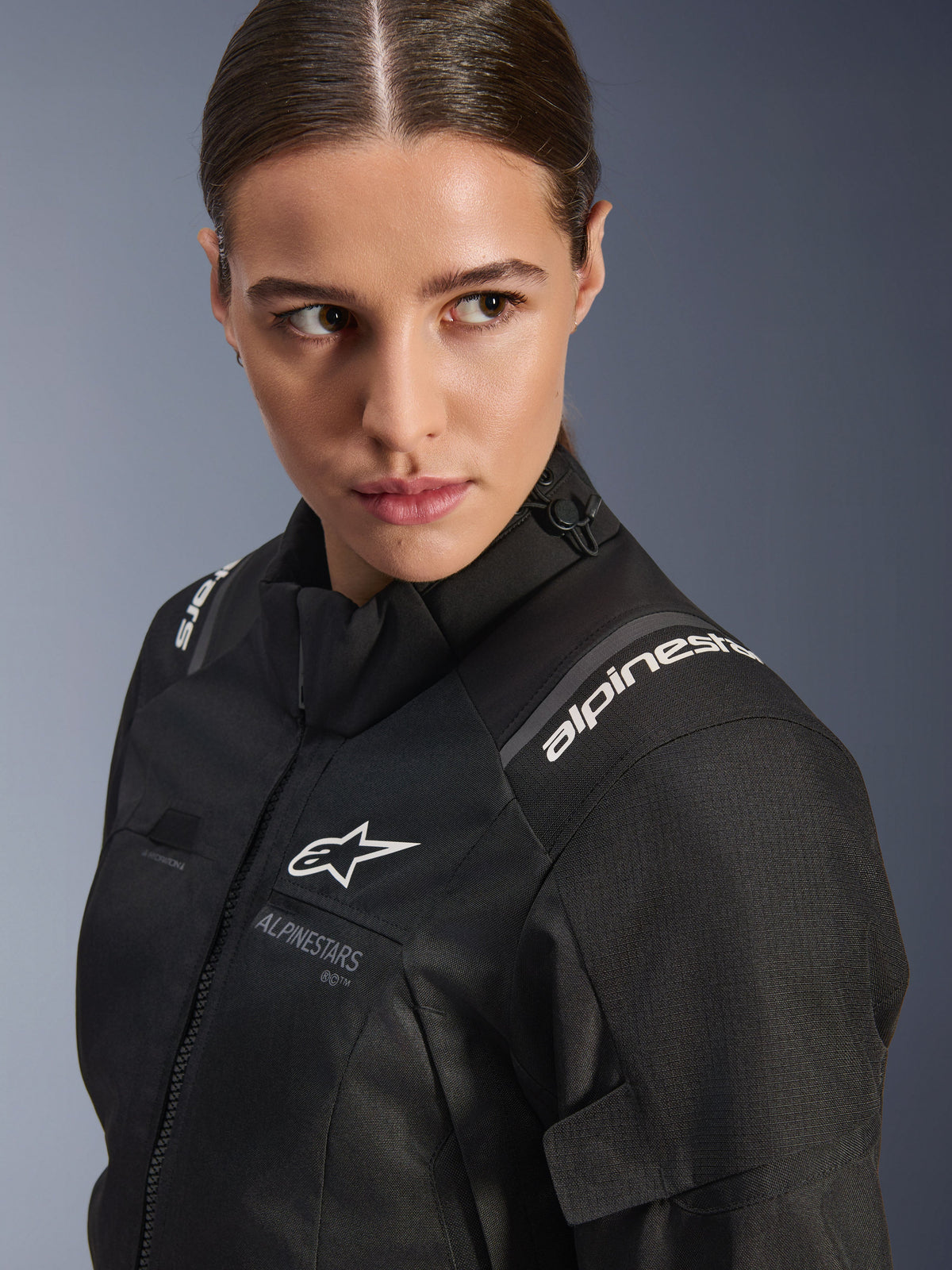 Alpinestars Stella Andes V4 Drystar® Damenjacke, schwarze Motorradjacke, Studio-Nahaufnahme von Oberkörper und Schulter, weiße Alpinestars-Logos, hochwertiges Textilmaterial und elegante feminine Passform