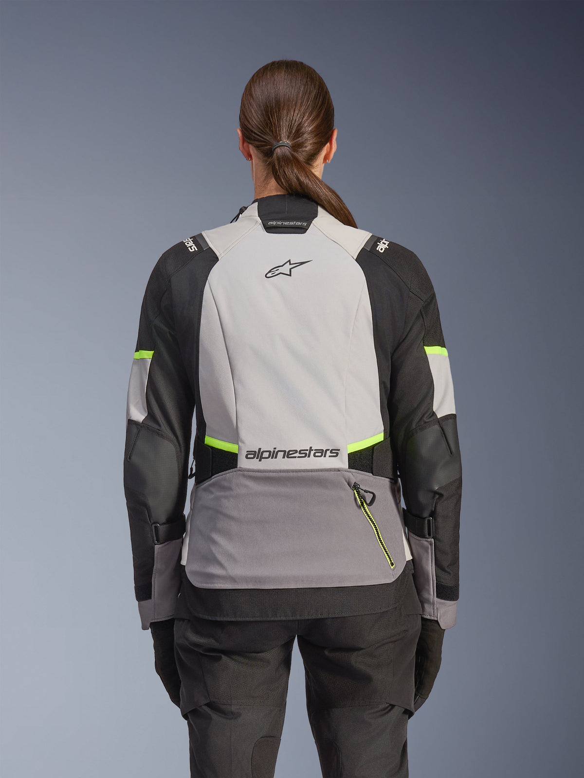 Alpinestars Stella Andes V4 Drystar® Jacke, Abenteuer-Motorradjacke für Damen, Rückansicht, Eisgrau, Dunkelgrau und Schwarz mit gelben Fluo-Akzenten, Alpinestars-Branding auf dem oberen und unteren Rücken, strapazierfähige Textilkonstruktion für Allwetter-Touren