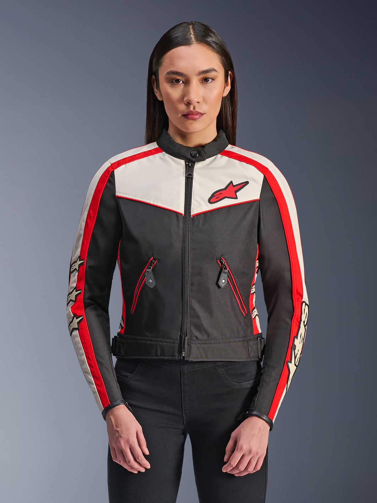Alpinestars Stella T-Dyno WR Jacke, Damen-Textil-Motorradjacke, Schwarz, Ecru und Hellrot, vintage-inspiriertes Design mit Frontreißverschluss, rote Ärmelstreifen mit Stern-Logos und Reißverschlusstaschen mit roten Akzenten.