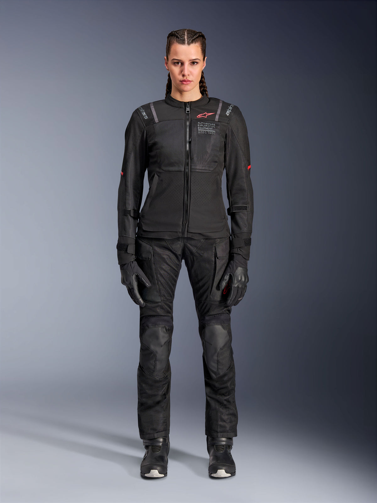 Alpinestars Stella ST-2 Air Jacke, Schwarz, Ganzkörper-Studioansicht einer Fahrerin in passender schwarzer Motorradhose und Handschuhen, mit High-Flow-Mesh-Einsätzen, roten Logo-Details und modernem Touring-Design
