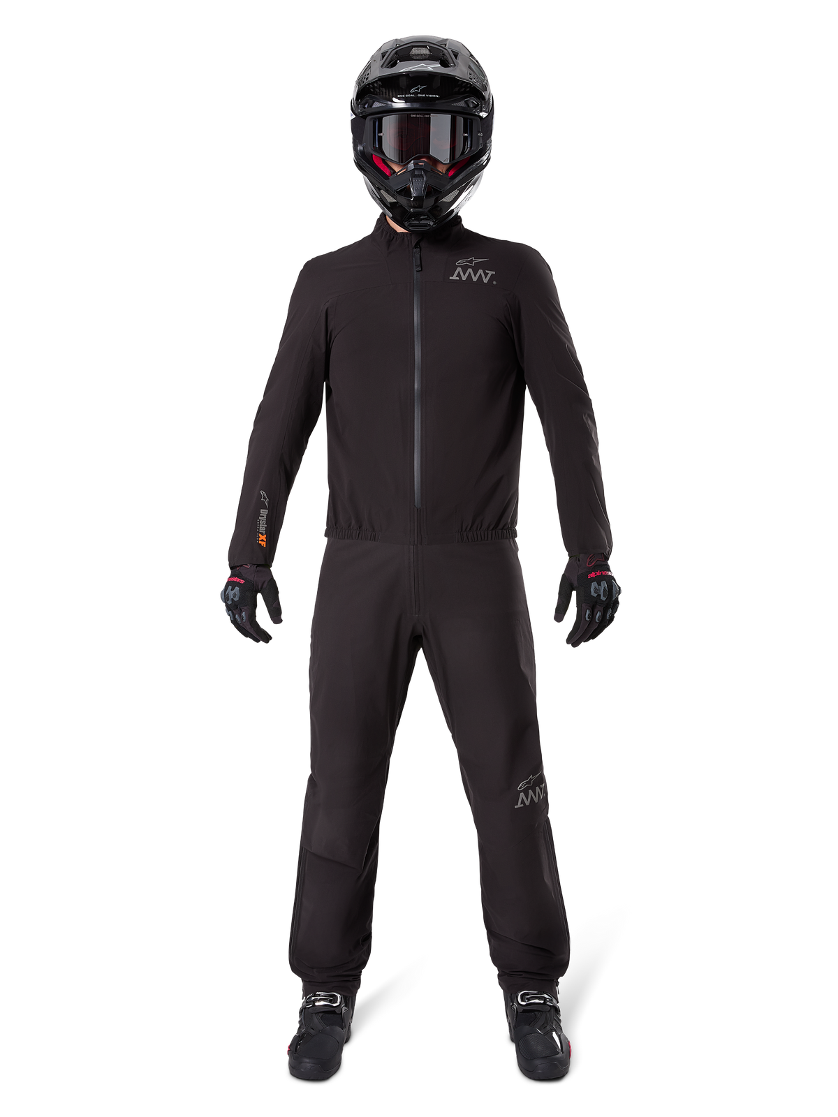Motorradfahrer in Alpinestars AMT-8 Stretch Drystar® XF Hosenfutter und passender Jacke, komplett schwarze wasser- und winddichte technische Ausrüstung, schwarzer Helm, Handschuhe und Stiefel, schlankes Adventure-Touring-Design.