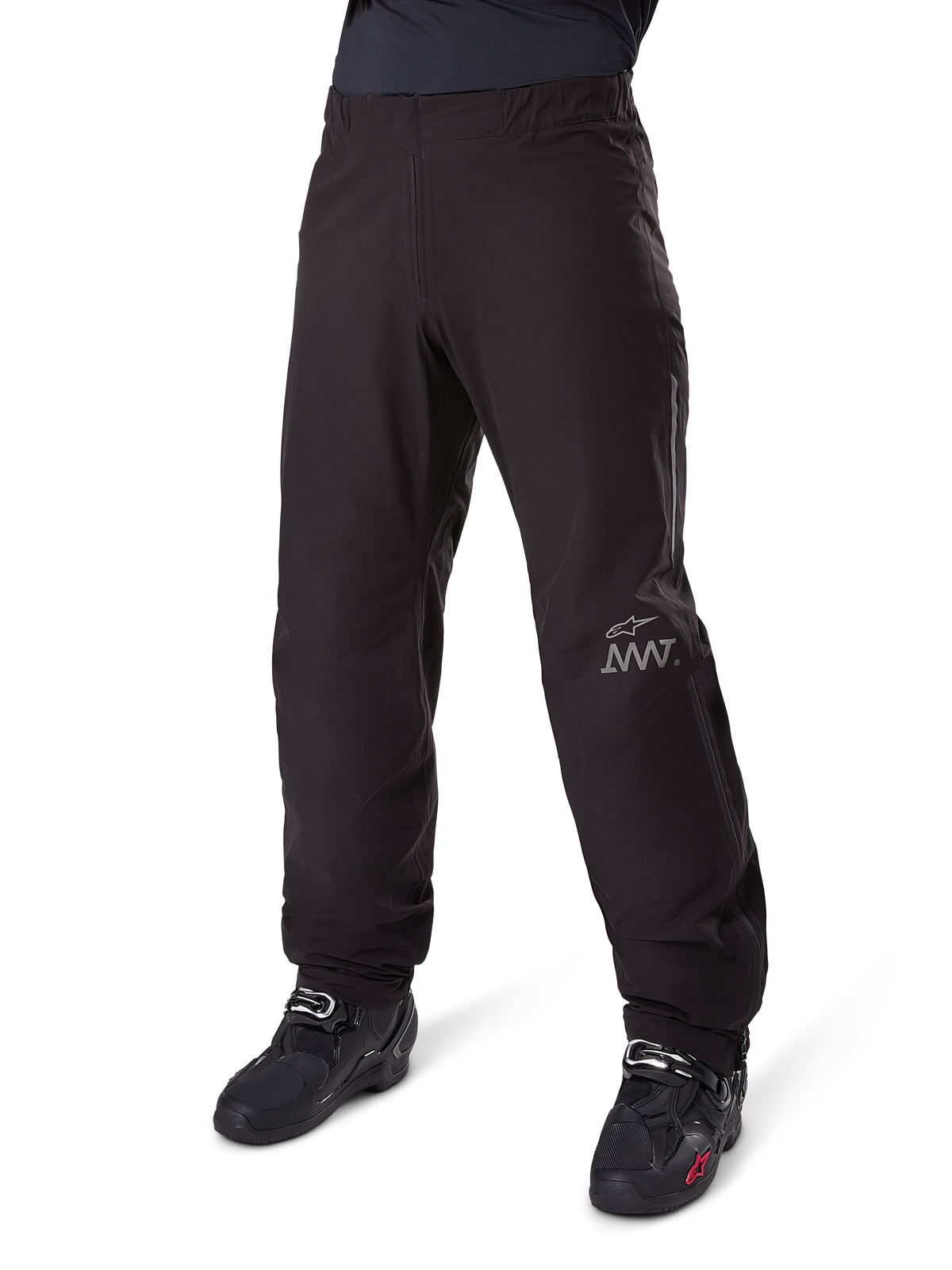 Alpinestars Amt-8 Stretch Drystar® XF Hosen-Innenfutter, Schwarz, wasserdichte und dehnbare Textilkonstruktion mit silbernem AMT-Logo, getragen mit schwarzen Motorradstiefeln, Komponente für Adventure-Touring-Motorradausrüstung