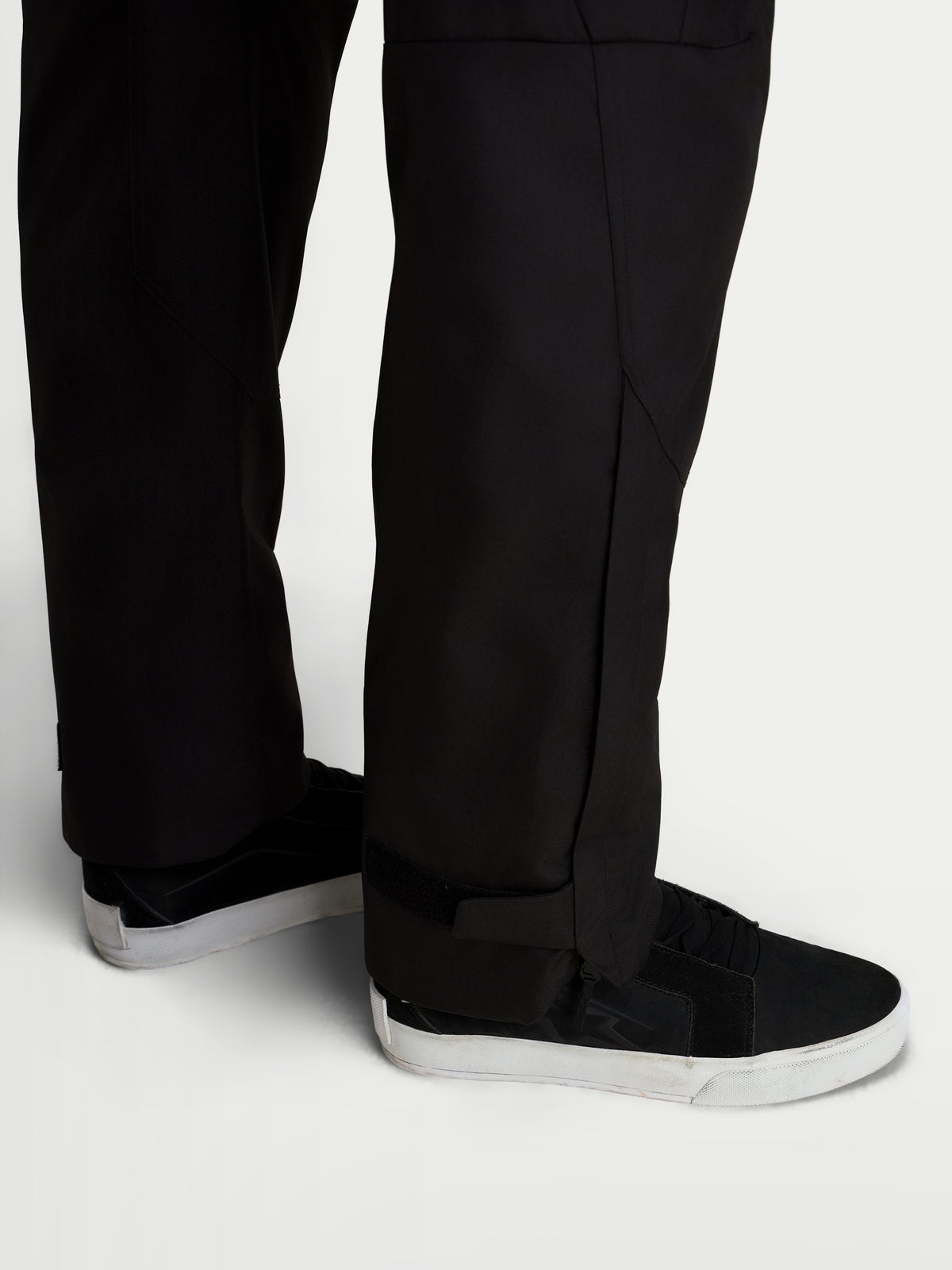 Alpinestars C-1 Waterproof Hose, urbane Herren-Motorradhose in Schwarz, Detailansicht des Unterschenkels im Regular-Schnitt und verlängerten Beinöffnungen getragen mit Motorradschuhen