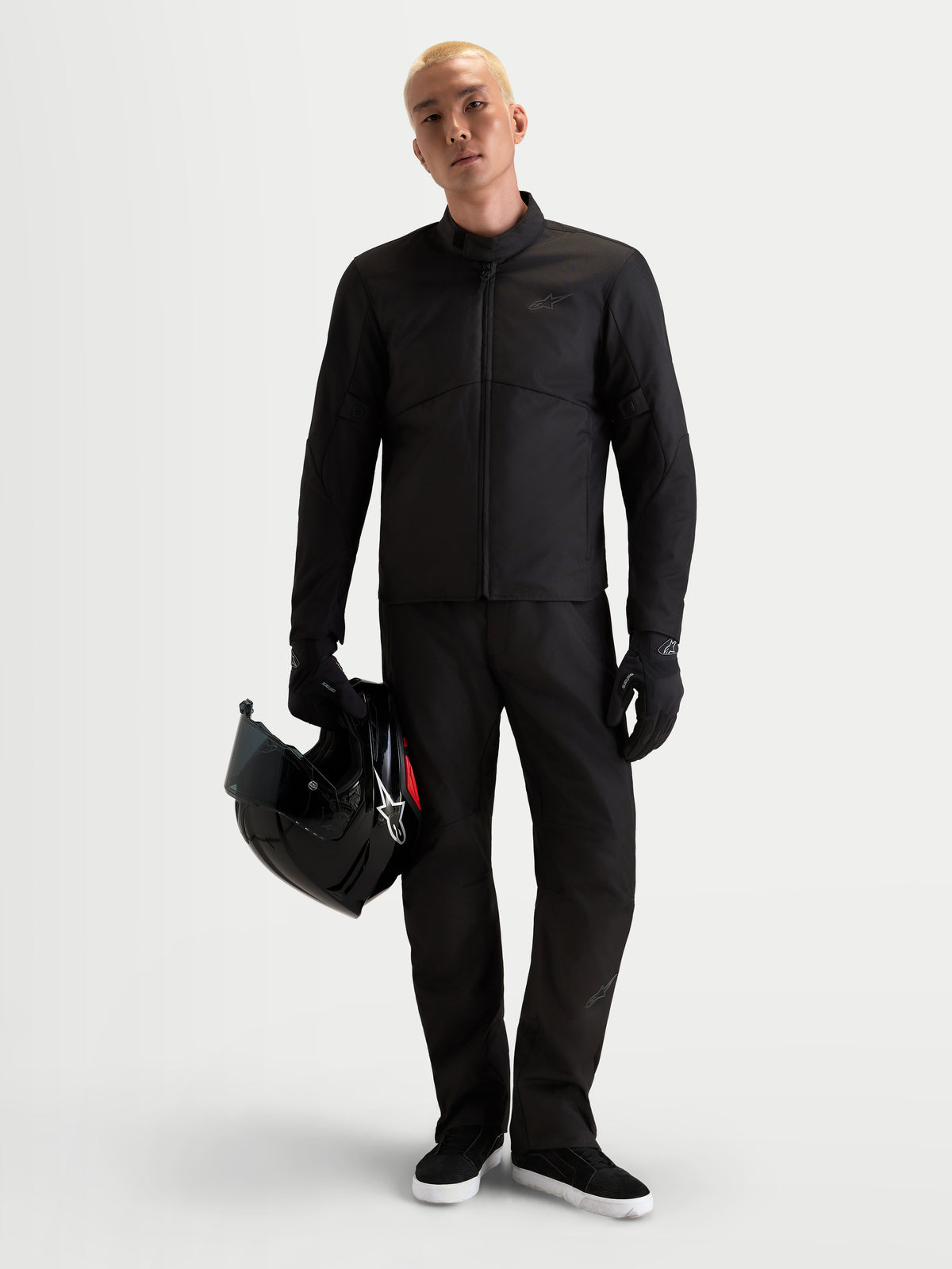Alpinestars C 1 Waterproof Hose, Herren-Urban-Motorradtouringhose in Schwarz, geradgeschnittene Winter-Reitbekleidung mit CE-zertifiziertem Schutz, getragen von einem Model, das einen Helm hält