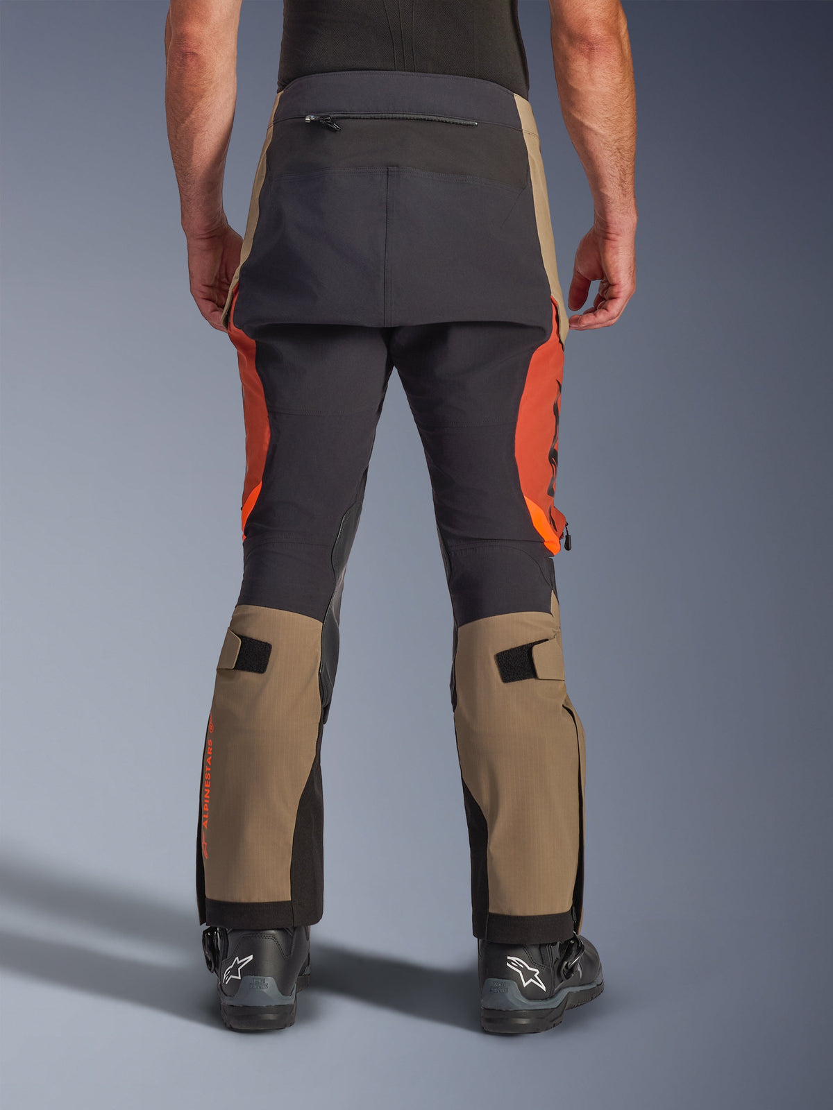Alpinestars Halo Pro Drystar® XF Laminated Pants in Walnut Rust Black, rear view, adventure motorcycle pants featuring walnut tan and rust orange panels with black seat reinforcement, includes zippered back pocket and adjustable calf volume straps