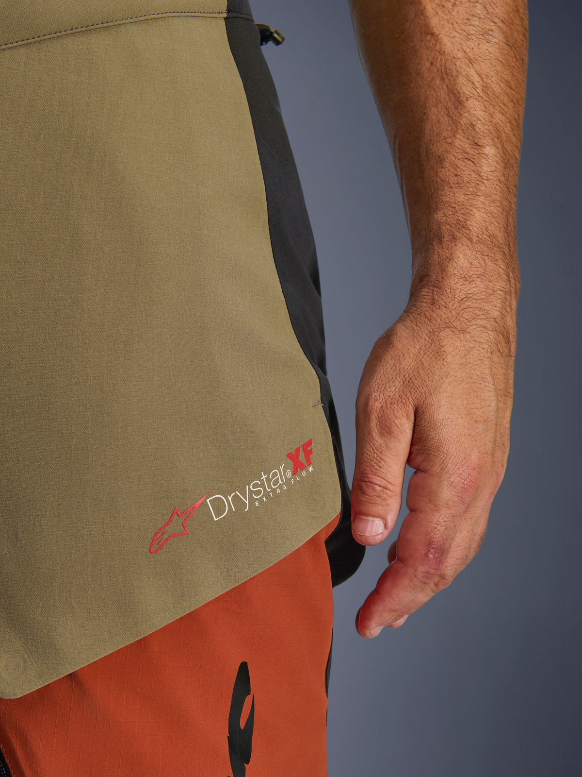 Alpinestars Halo Pro Drystar® XF Laminated Pants, Walnut Rust Black, close-up detail of the Drystar XF Extra Flow branding, showing the olive green and rust orange textile panels and technical construction.