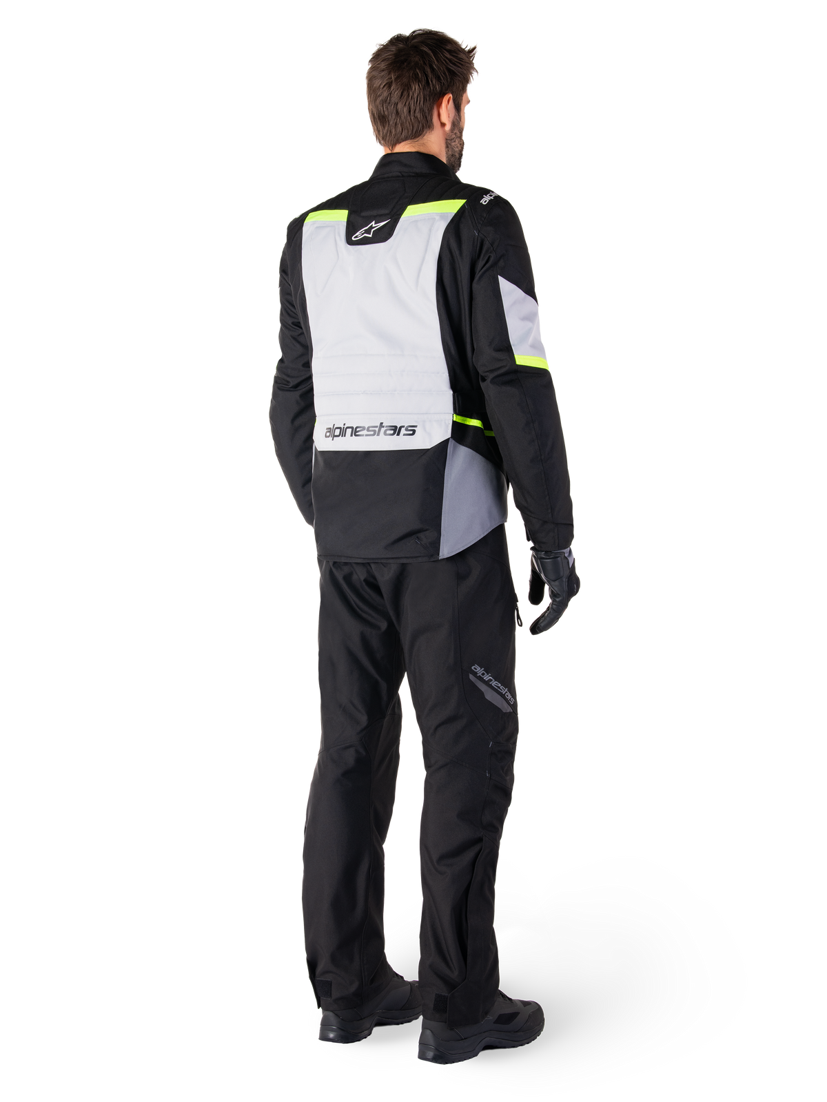 Alpinestars ST-1 Waterproof Pants, Black, rear view on a rider paired with a matching adventure touring jacket featuring gray and fluorescent yellow accents, worn with black boots and gloves, coordinated outfit for all-weather road and adventure riding