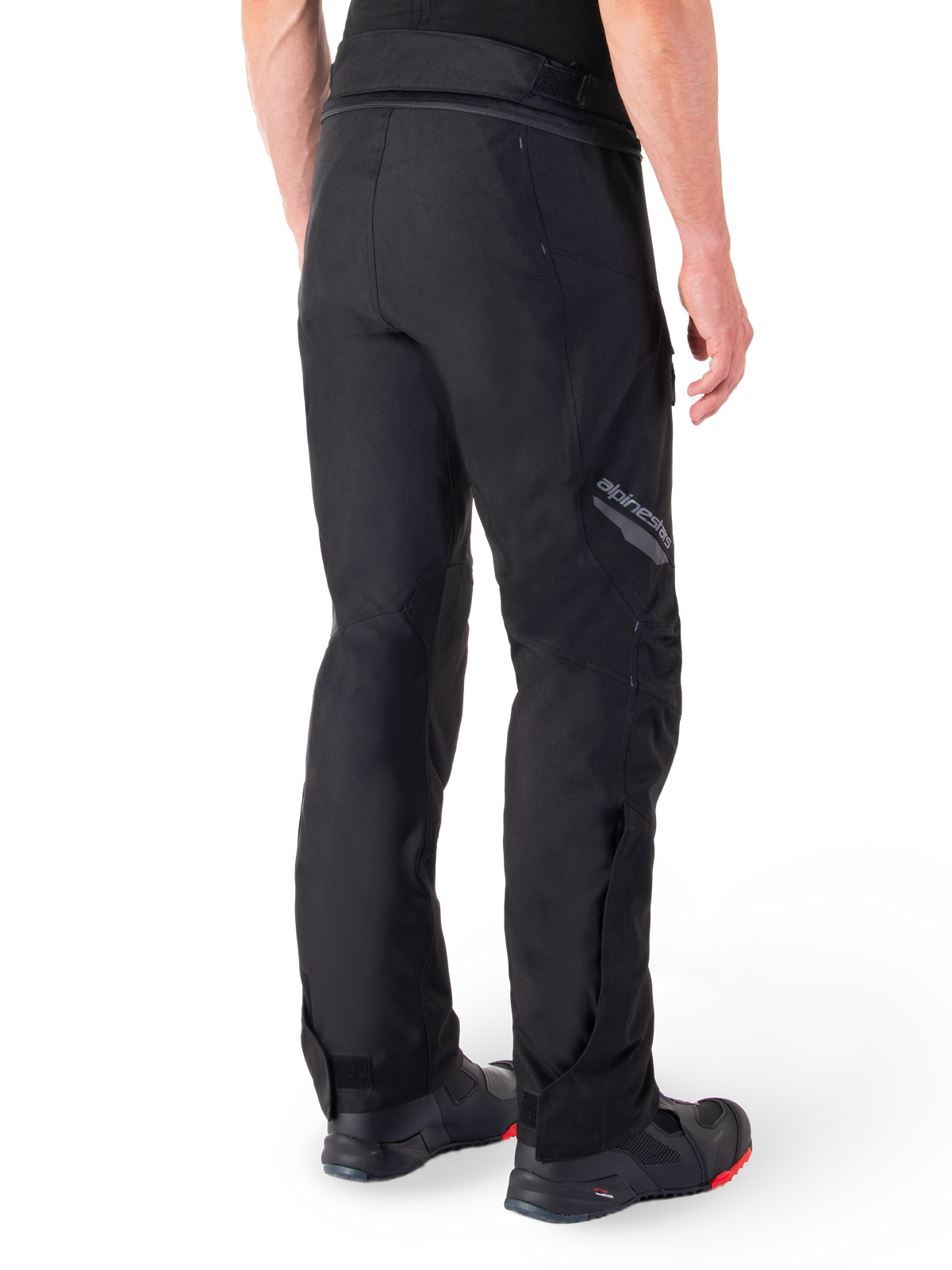 Alpinestars St-1 Waterproof Pants, Black, rear view showing textile construction and Alpinestars branding on the thigh, worn with black motorcycle boots, adventure touring style