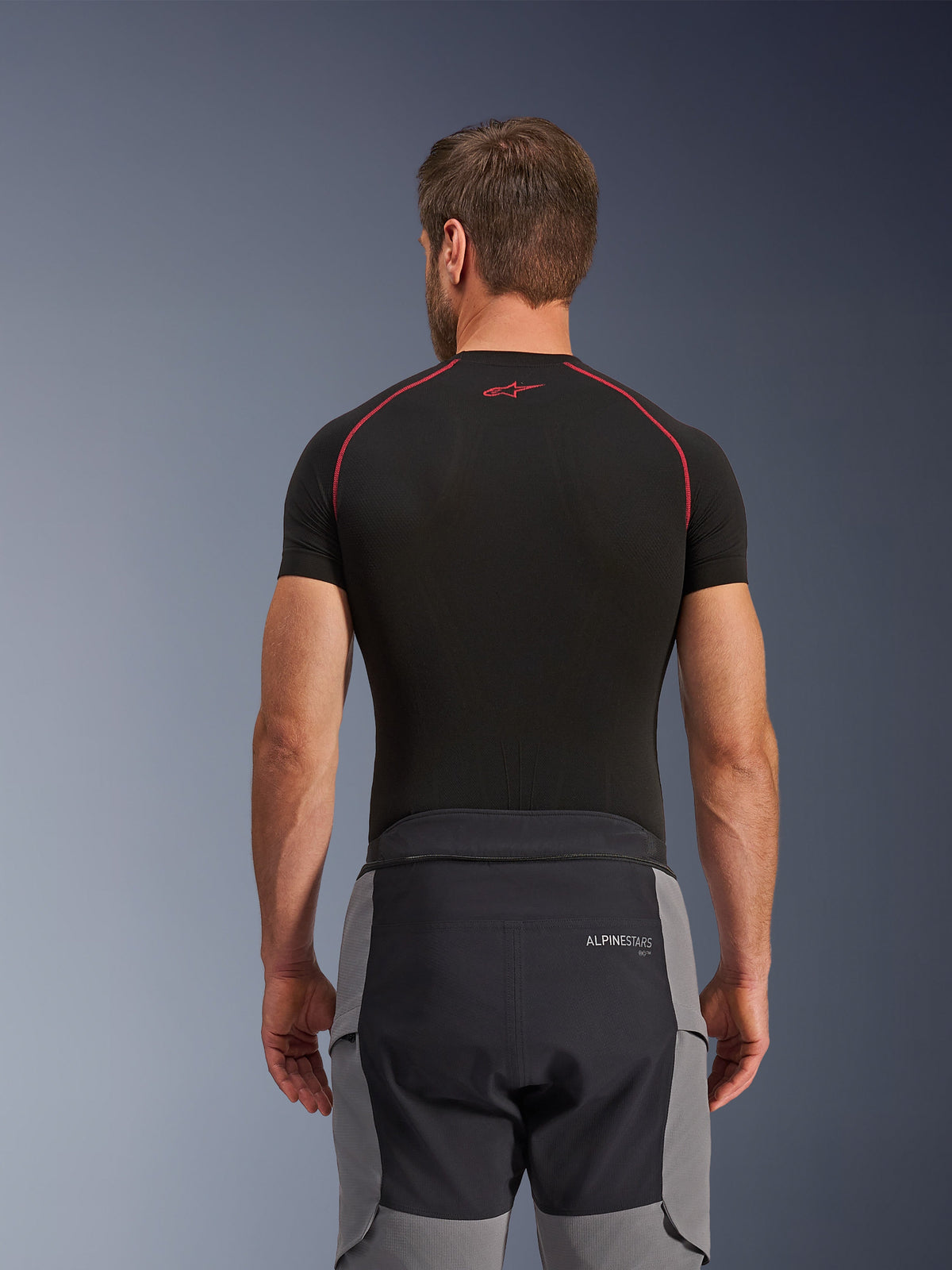 Alpinestars Andes Pro Drystar® XF Pants, Adventure Motorcycle Pants, Dark Gray and Black, rear view showing waist construction and gray side panels, worn with a black base layer top featuring red stitching, technical all-weather touring gear.