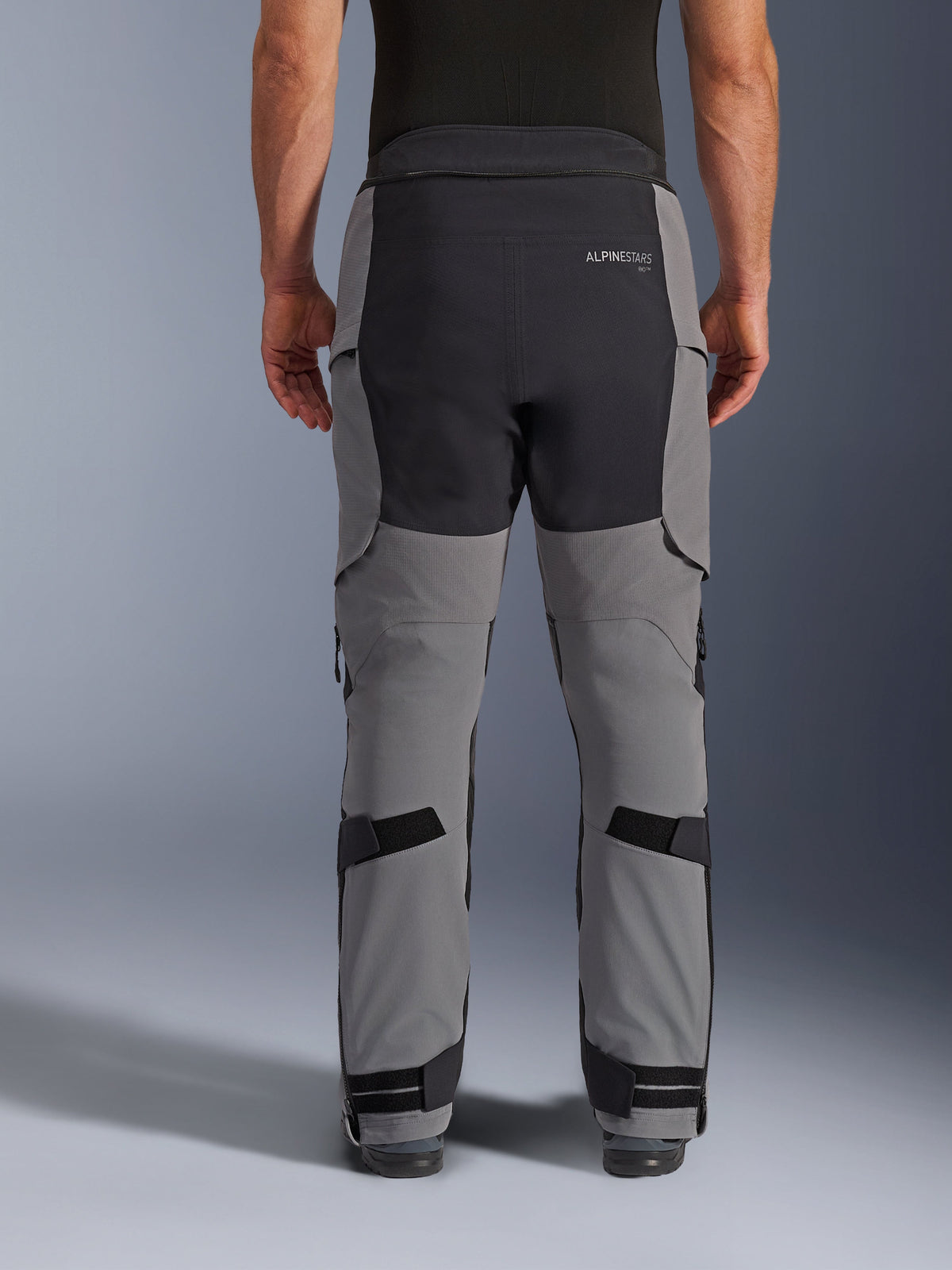Alpinestars Andes Pro Drystar® XF Pants, Back View, Dark Gray and Black, adventure motorcycle pants featuring black reinforced panels on the seat, rear Alpinestars logo, and adjustable straps behind the knees and at the ankles for a secure fit.