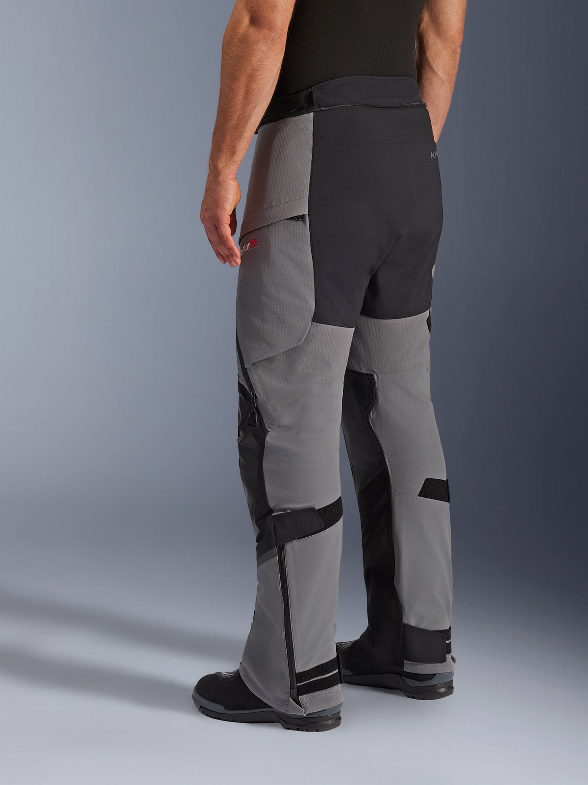 Alpinestars Andes Pro Drystar® XF Pants, Adventure Motorcycle Pants, Dark Gray and Black, rear three-quarter view, featuring textile construction with black reinforced seat and inner leg panels, zippered lower legs, and adjustable tabs.