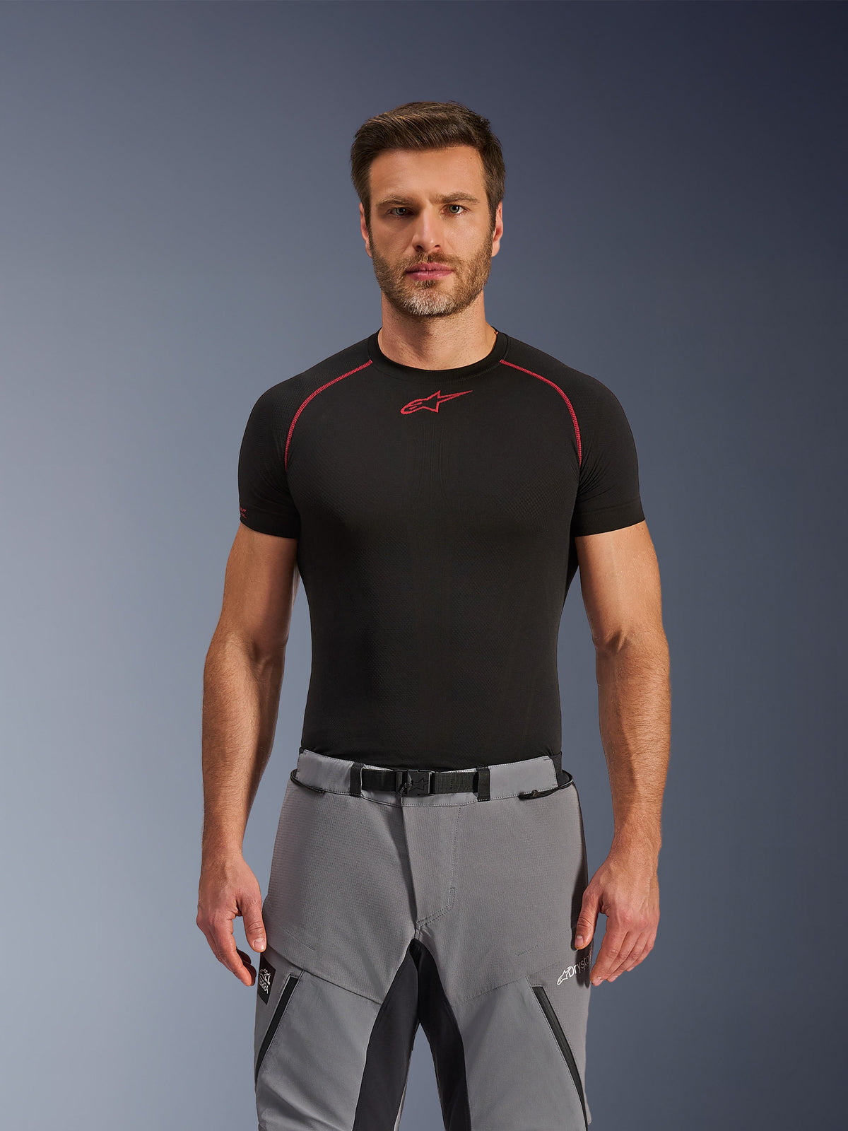 Alpinestars Andes Pro Drystar® XF Pants, Adventure Motorcycle Pants, Dark Gray and Black, worn by a male model with a black technical base layer, featuring a magnetic buckle waist, durable textile construction, and Drystar® XF branding for all-weather touring.