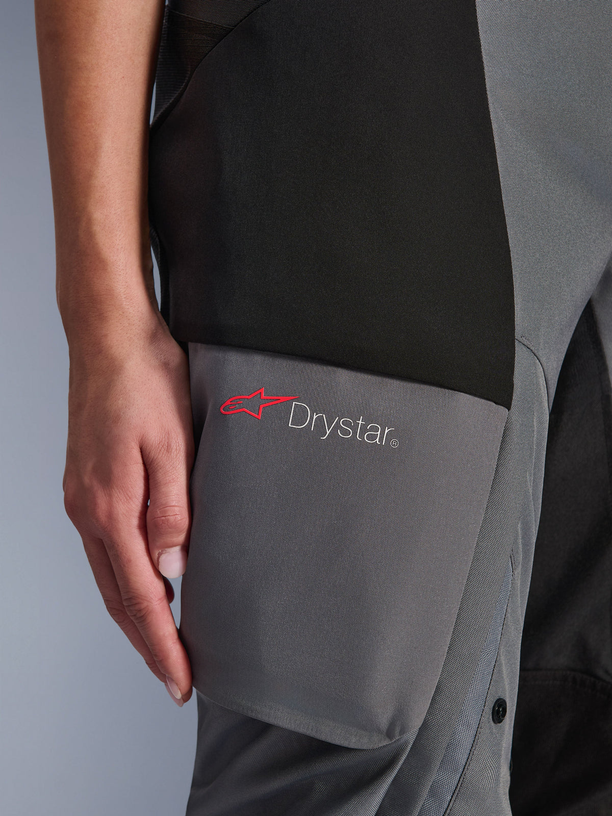 Alpinestars Stella Andes V4 Drystar® Pants, Women's Adventure-Touring Pants, Black and Dark Gray, detail of the thigh area showing the Drystar logo and red Alpinestars star on reinforced textile panels