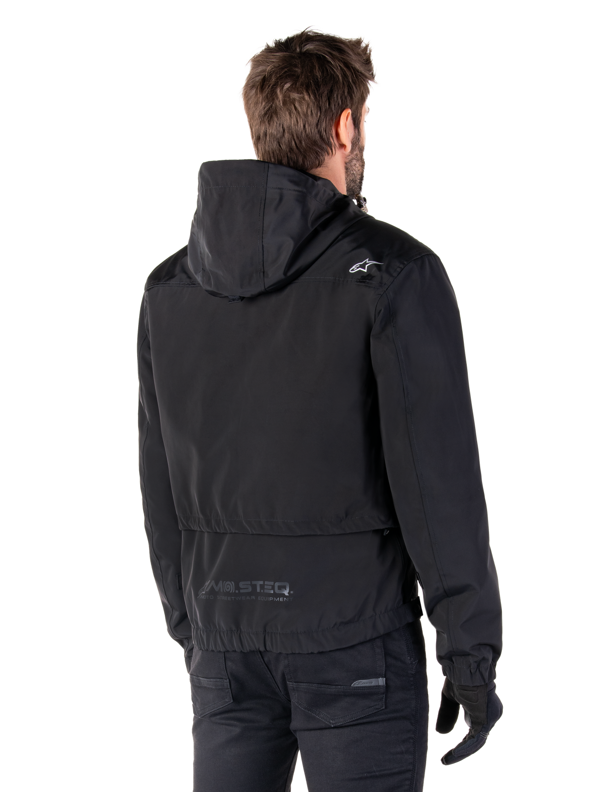 Alpinestars Mootant Waterproof Parka, Black Motorcycle Jacket, Rear view showing hooded design, white logo on shoulder and MO.ST.EQ. reflective branding on lower back, urban contemporary riding gear