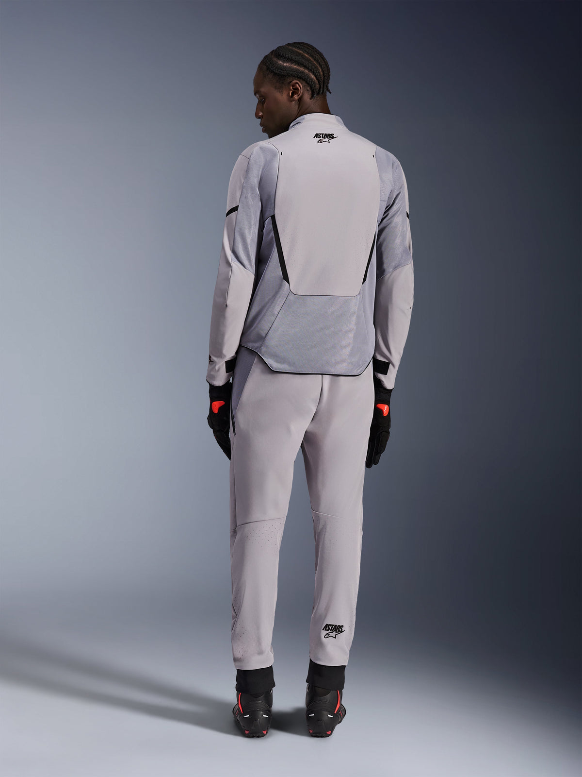 Alpinestars Aeroshell Airflow Jacke, Mid Gray Anthracite, Rückansicht an einem Model, mit technischen Mesh-Einsätzen und laserperforierten Belüftungszonen, getragen mit passender grauer Hose und schwarzer Motorradausrüstung, sportlicher Schnitt für hohe Performance.