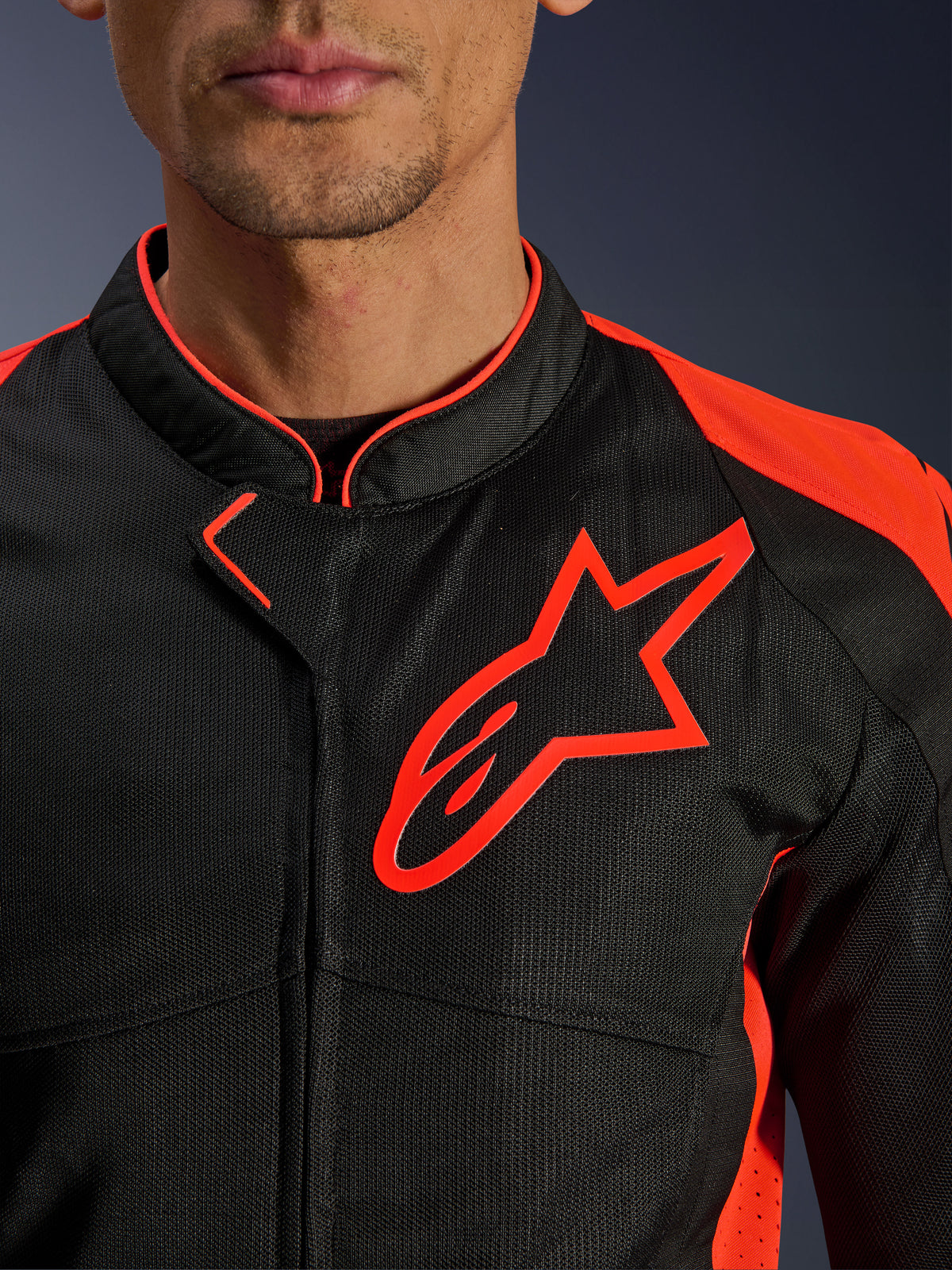 Alpinestars Viper Air V4 Jacke in Red Fluo Black, Nahaufnahme von Brust und Kragen, mit schwarzer Tech-Mesh-Konstruktion, einem markanten roten Alpinestars-Logo und leuchtend roten Akzenten an den Schultern.