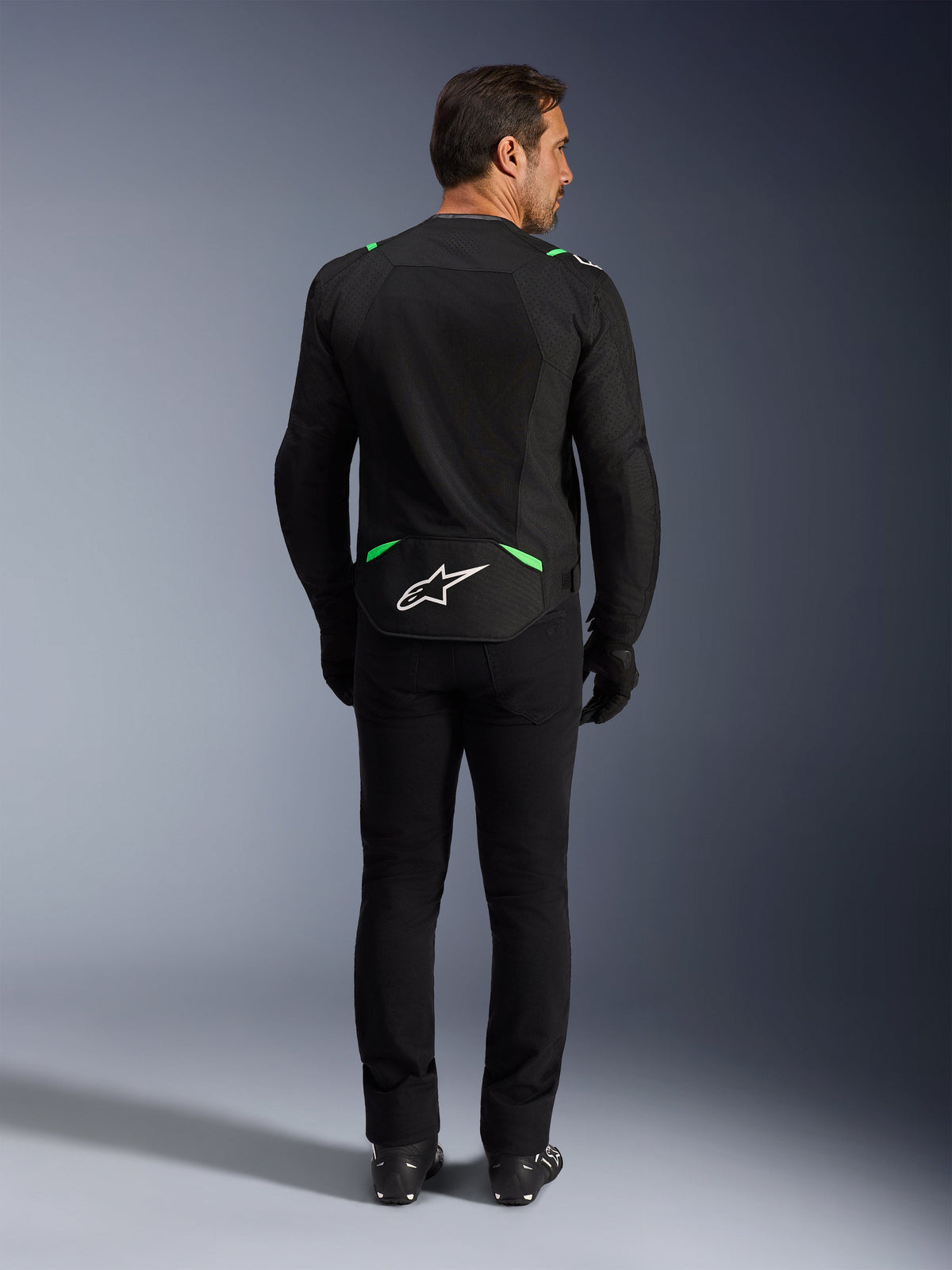 Alpinestars T-SPS Air V2 Jacket, Motorcycle Jacket, Black and Fluo Green, rear view featuring white logo on lower back, worn with matching black pants and boots, ventilated mesh design for sport riding