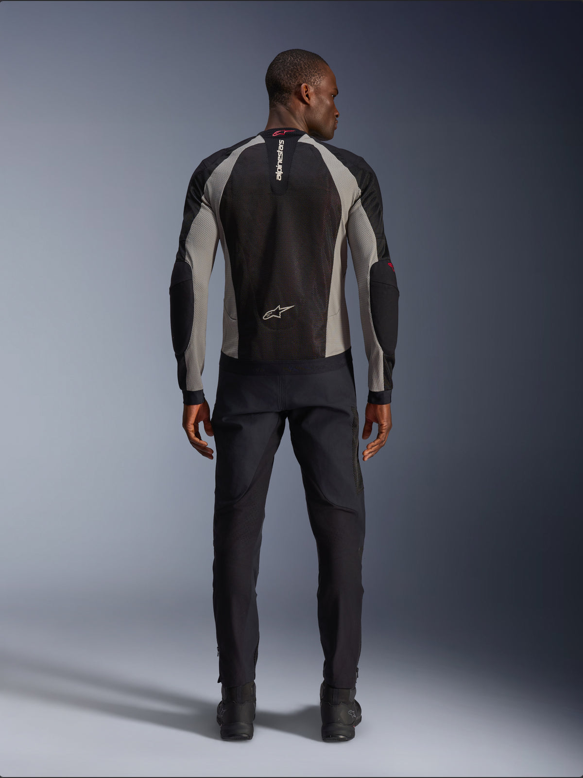Alpinestars Troop-Air Jacket, Black Ash Gray and Bright Red motorcycle jacket, rear view on male model, lightweight mesh construction for ventilation, Alpinestars branding on collar and lower back, paired with black riding pants