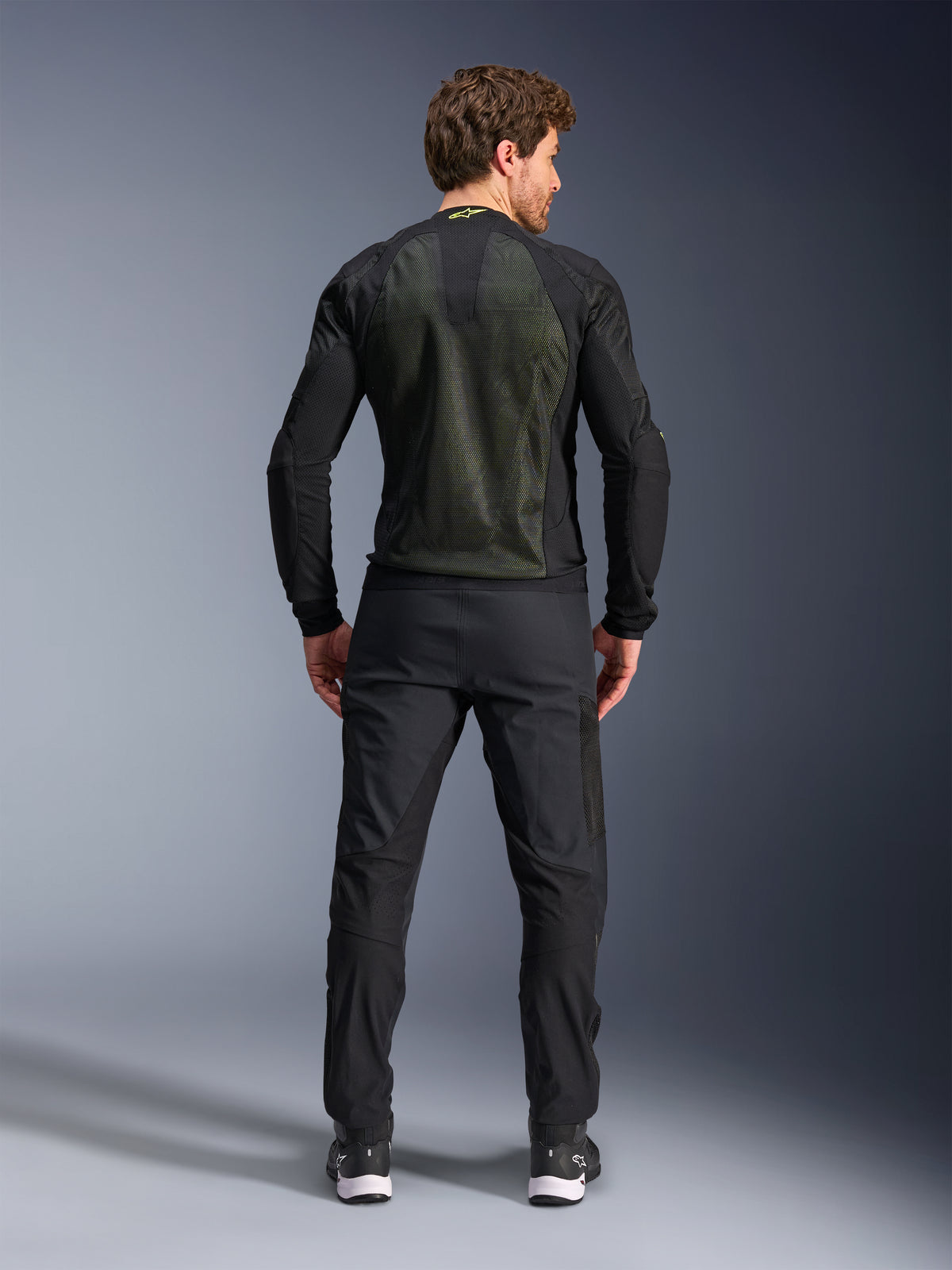Alpinestars Troop-Air Jacket, Black Yellow Fluo, back view on a model, featuring a large 2D tech mesh back panel for ventilation, technical motorcycle jacket worn with black riding pants and boots, urban motorcycle style