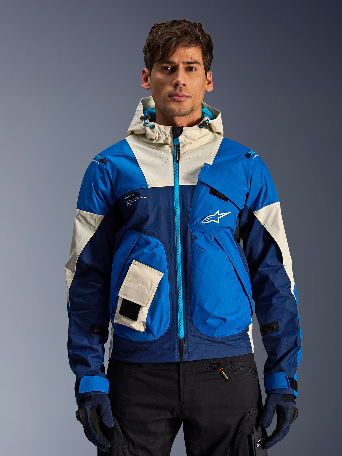 Alpinestars Mogress Air Jacke, urbane Herren-Motorradjacke, Blau und Almond, belüftete Kapuzenjacke, getragen am Model.