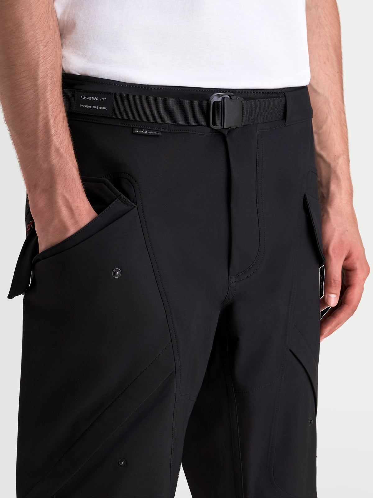 Alpinestars Juggernaut V 2 Drystar Hose, urbane wasserdichte Herren-Motorradhose in Schwarz, Nahaufnahme mit verstellbarem Gürtel, Magnetschnalle und seitlichen Cargotaschen am Model