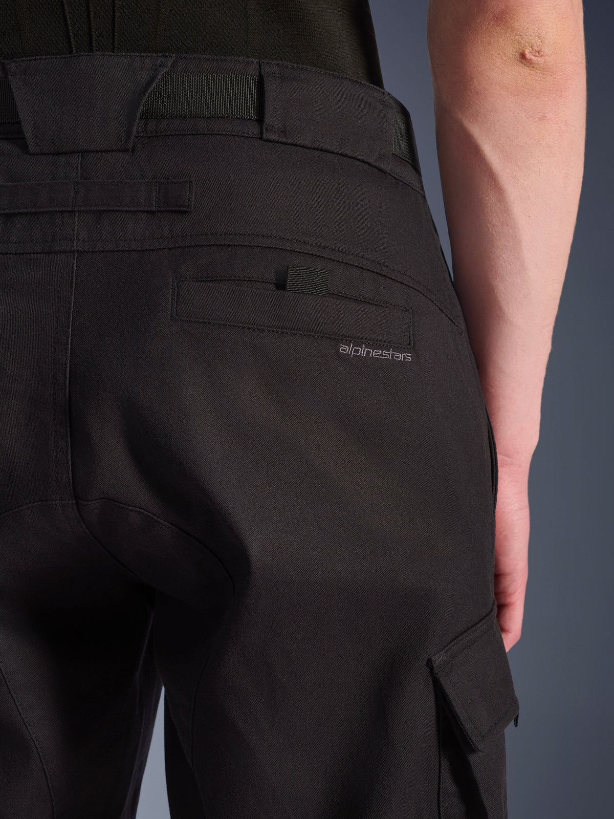 Close-up of Alpinestars Flex-AST Cargo Pants in Black, urban motorcycle pants featuring a detailed rear pocket with subtle branding, large belt loops, and a side cargo pocket on durable stretch textile.