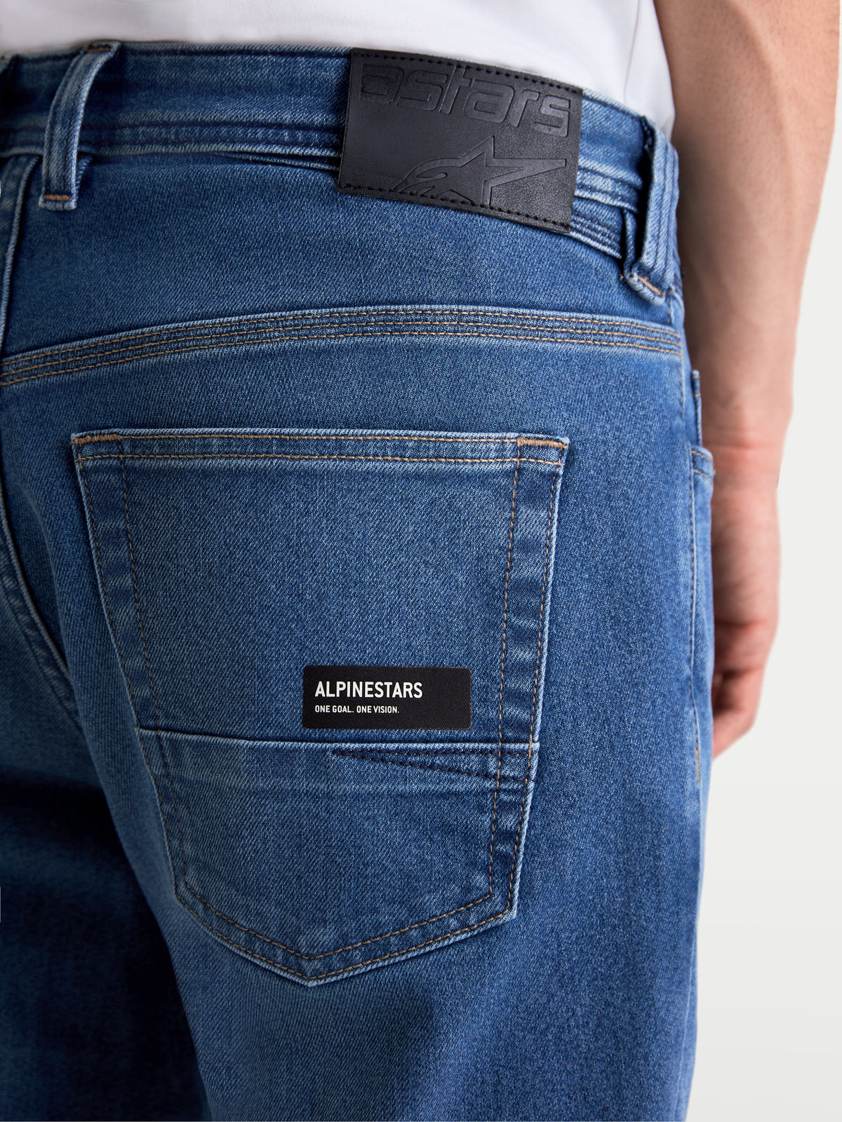 Alpinestars Flex-AST 7 Denim Pants, men's urban motorcycle riding jeans in light blue, close-up view of the back pocket with Alpinestars branding, leather back patch, and single-layer technical denim construction