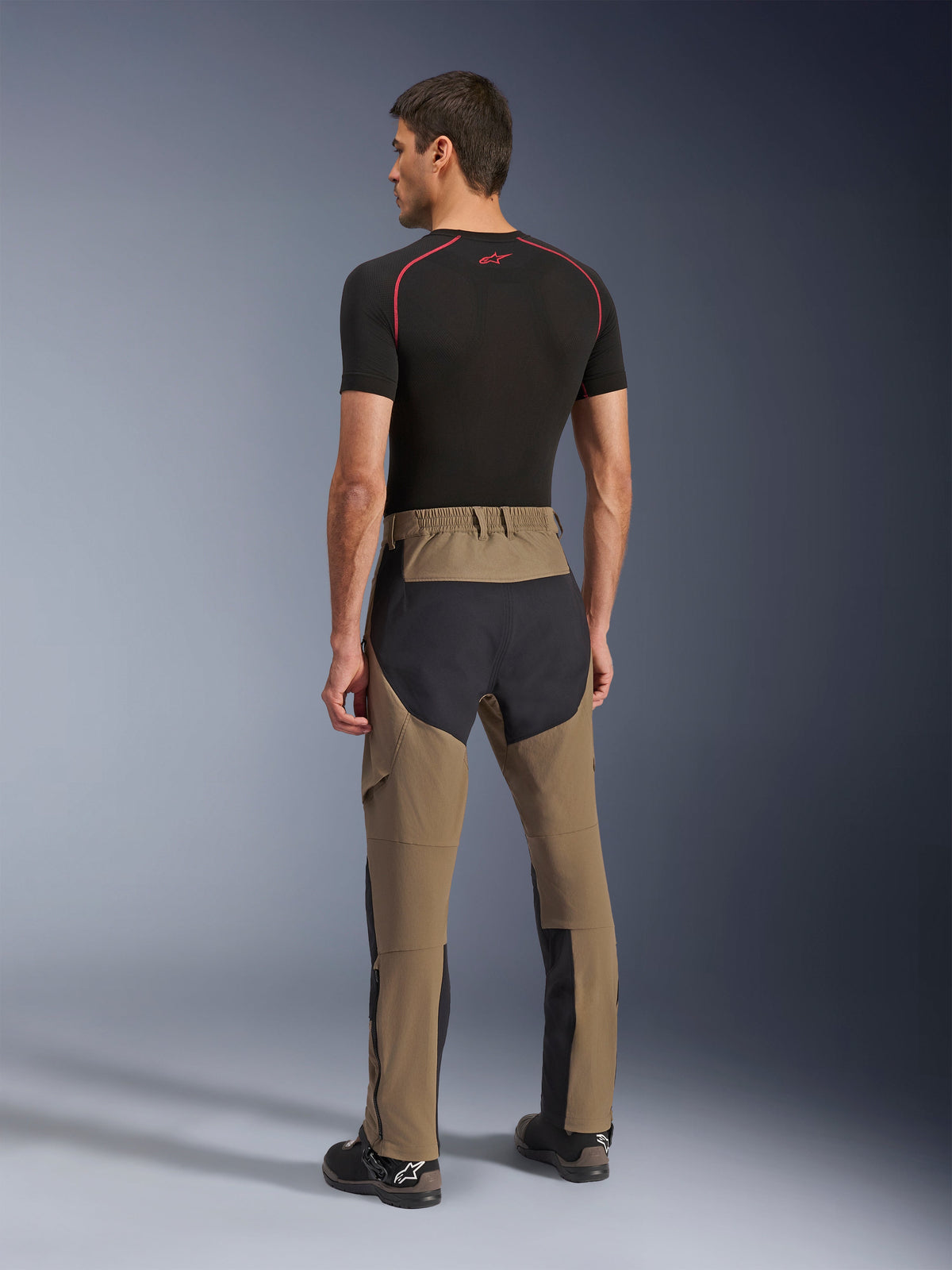 Alpinestars Flex-AST Explorer Pants, Adventure Motorcycle Pants, Walnut Black, rear view on model showing black ripstop seat and leg panels, stretch textile construction, and long lower-leg zippers for adventure touring