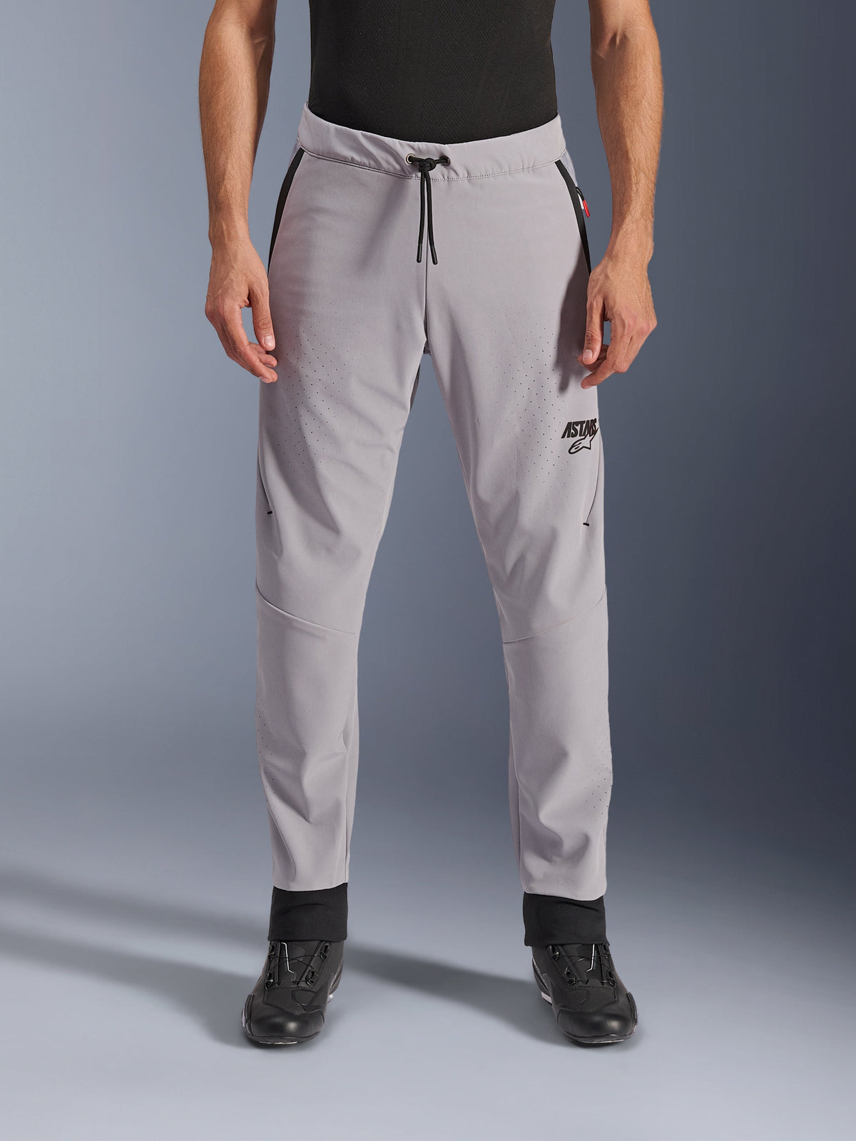Alpinestars Aeroshell Airflow Pants, Mid Gray, front view showing laser-perforated zones on thighs and shins, black drawstring waist and black ASTARS logo, lightweight softshell chassis for warm weather riding