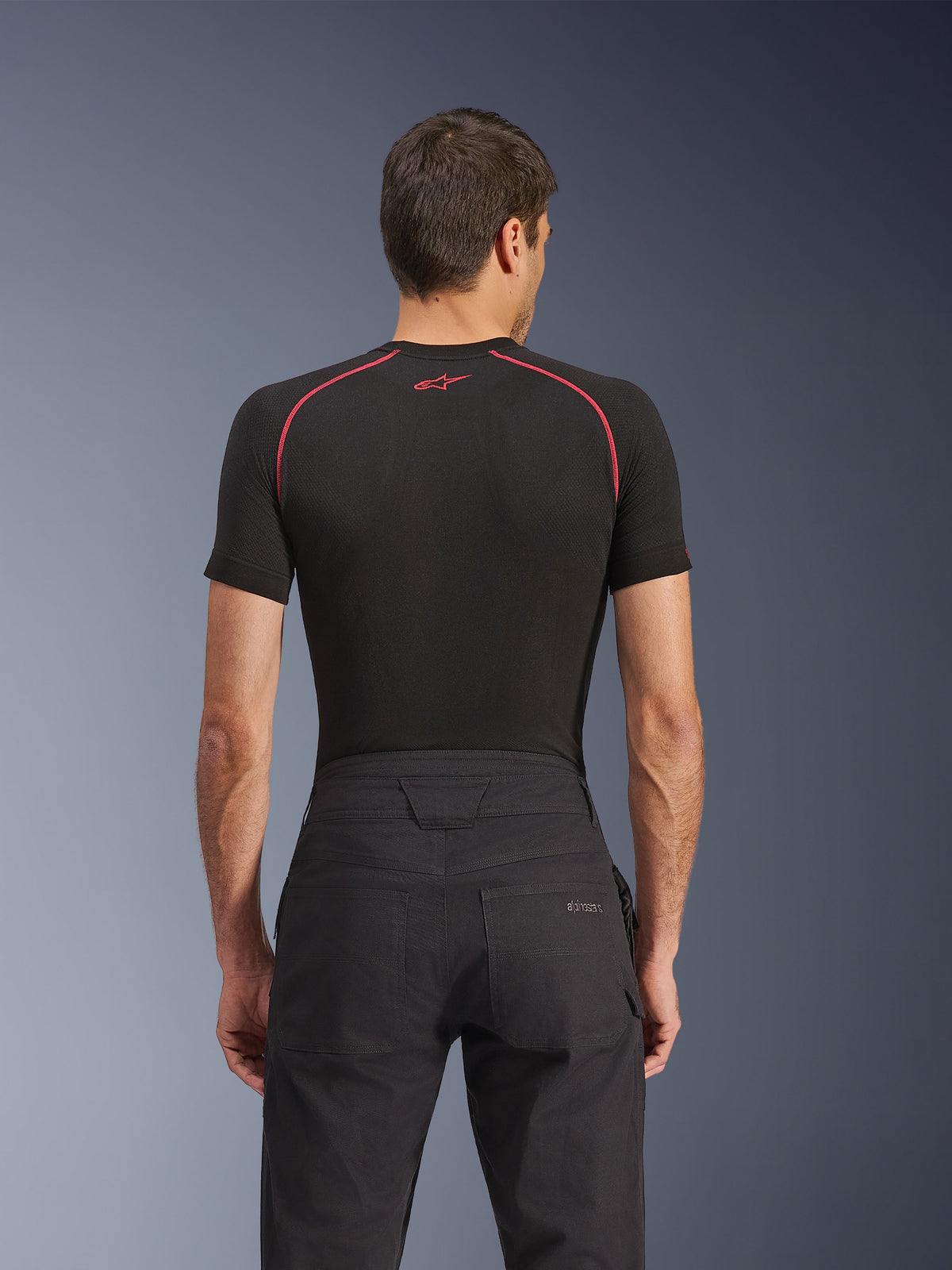 Alpinestars Flex-AST Canvas Pants, Urban Motorcycle Pants, Black, back view featuring the rear pocket with embroidered Alpinestars logo, reinforced waistband and contrast topstitching, styled with a black performance base layer.