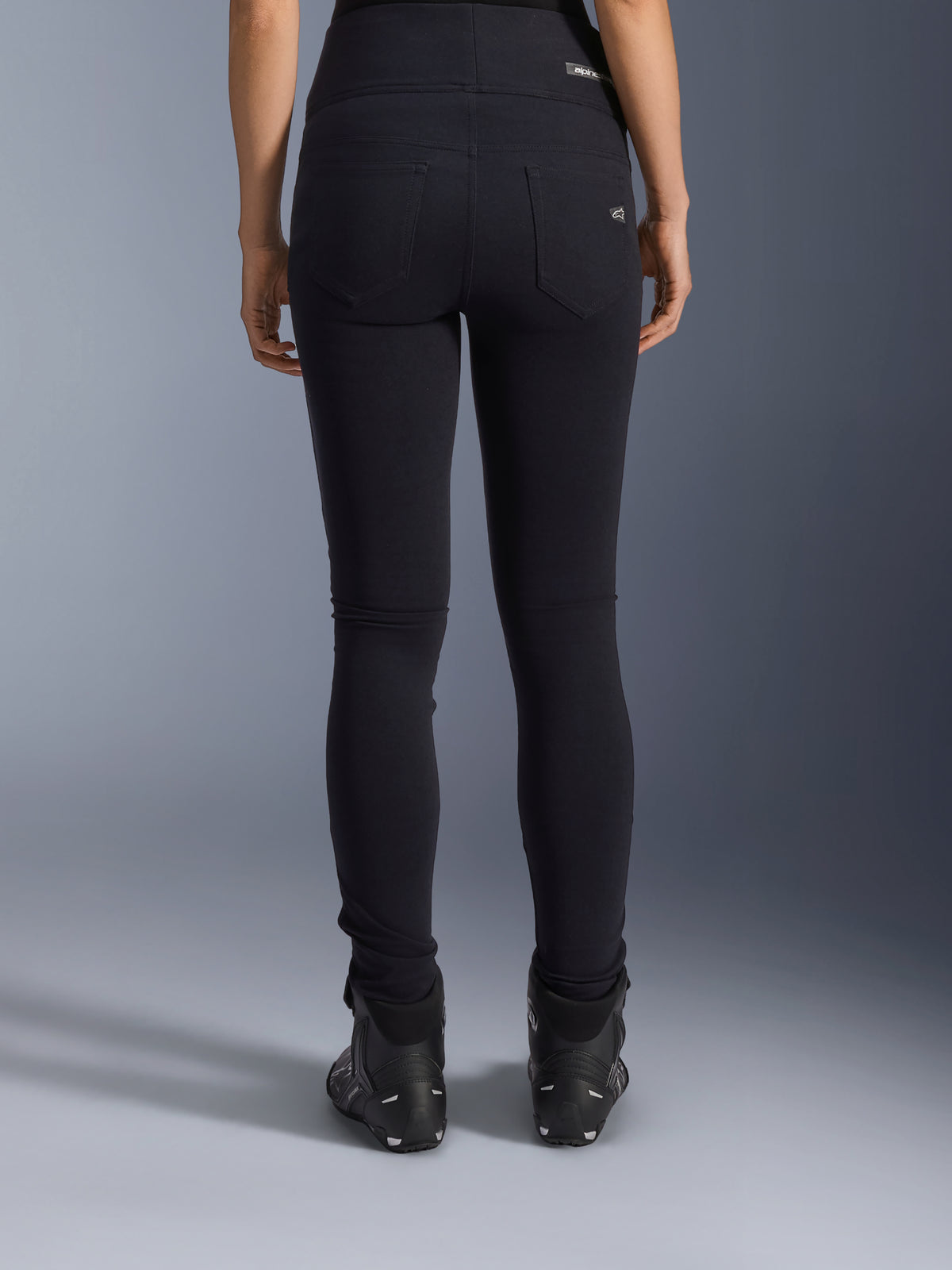 Alpinestars Stella Flex-Ast Leggings, Damen-Motorrad-Leggings, Schwarz, Rückansicht mit Gesäßtaschen und schmaler Passform, getragen mit schwarzen Motorradstiefeln, urbaner Fahrstil