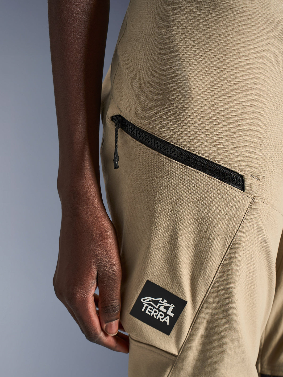 Alpinestars Stella Flex-AST Explorer Hose, Motorradhose für Damen, Sand, Detailaufnahme der Cargo-Tasche mit Reißverschluss und schwarzem ALL TERRA Logo-Aufnäher, strapazierfähige Ripstop-Textilkonstruktion für Adventure-Touren