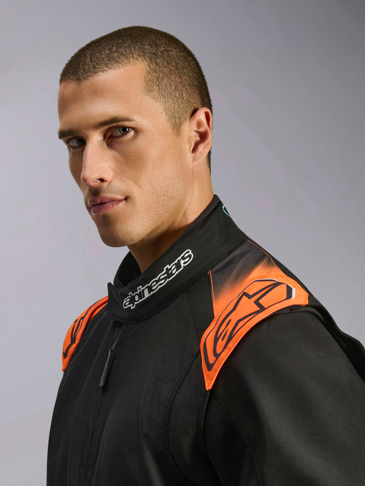 Alpinestars KMX-5 V3 Kombi, Kartkombi, Schwarz und Orange Fluo, FIA-zertifiziert, Detail von Kragen und Schultern am Modell.