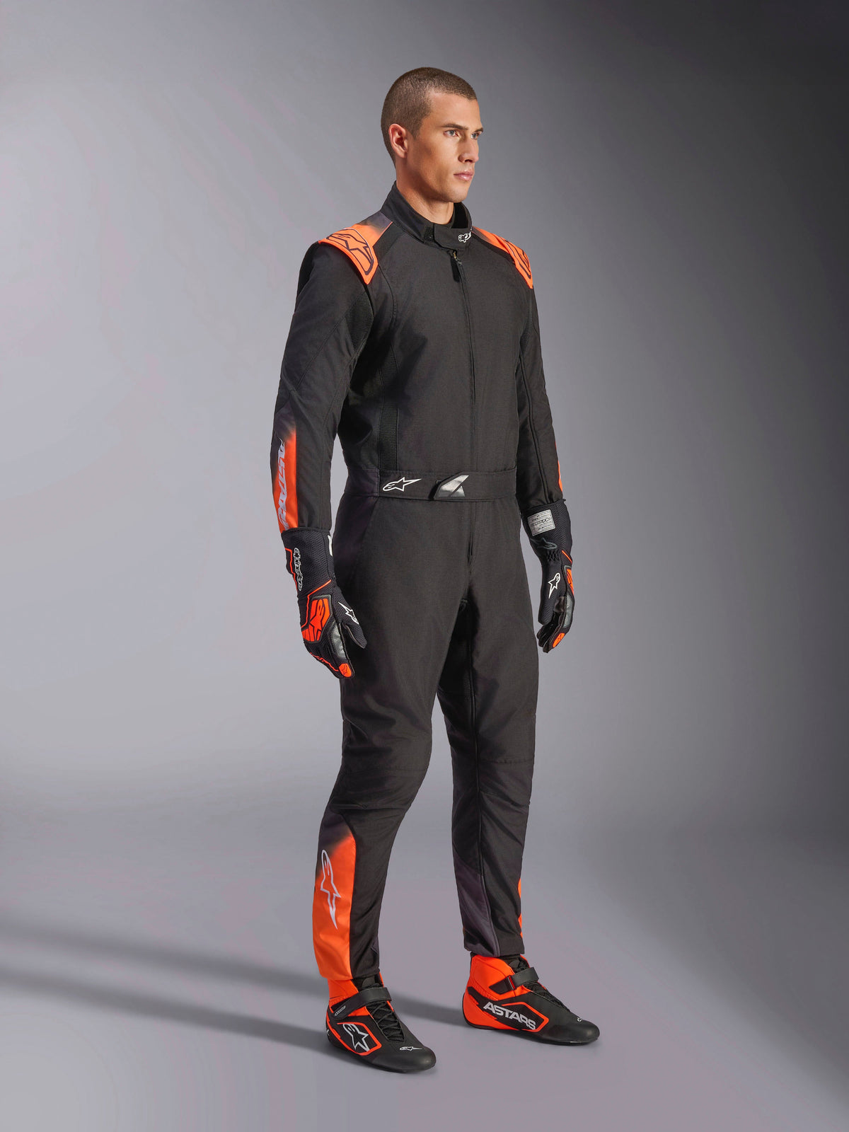 Alpinestars KMX-5 V3 Kombi, Herren-Kartanzug, Schwarz und Orange Fluo, FIA Grad 1 Textil-Renneinteiler, am Model getragen.