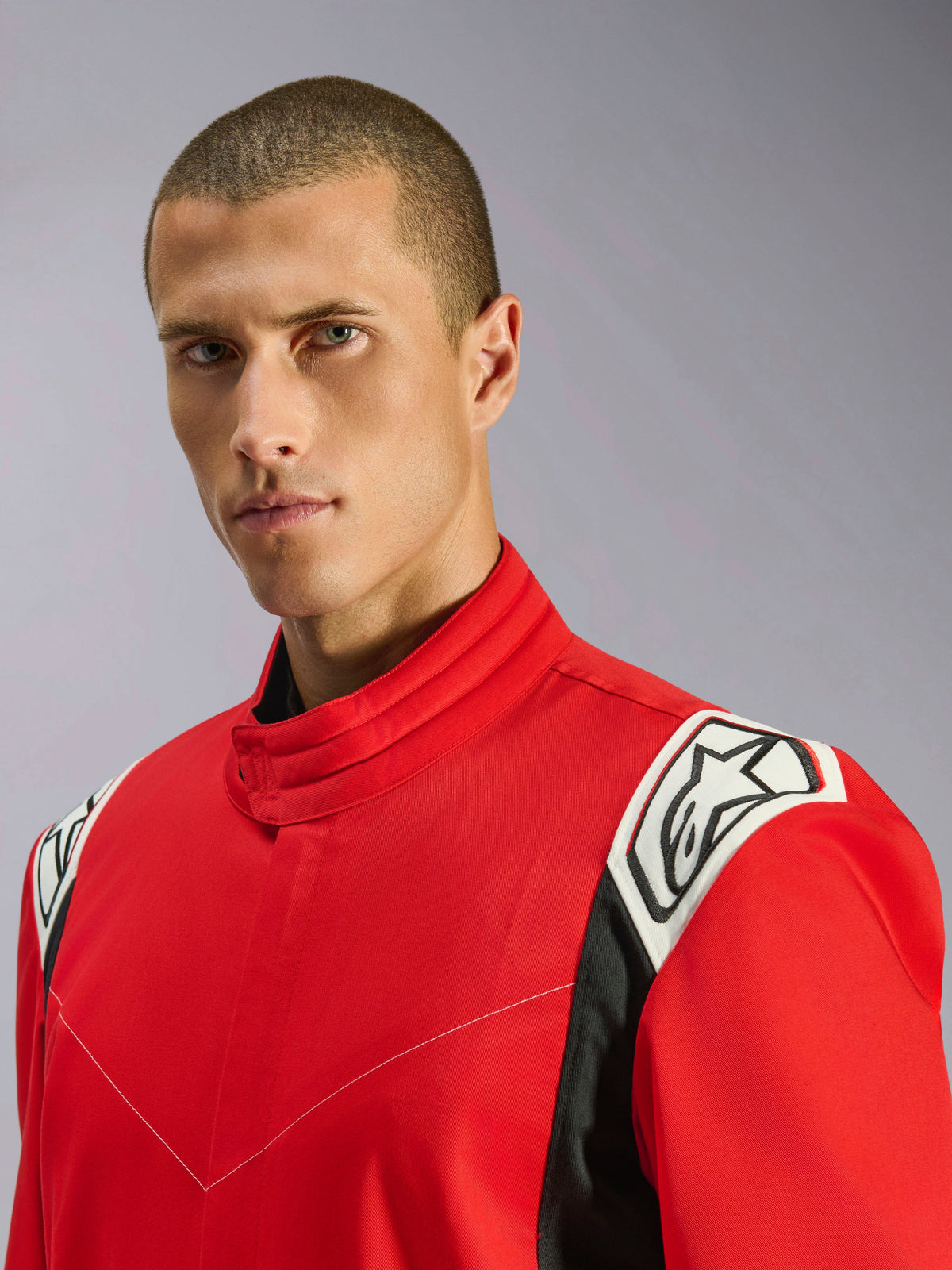 Alpinestars Kart Indoor V2 Anzug in Rot, Nahaufnahme eines männlichen Models im Anzug, Fokus auf den ergonomischen Kragen und die weiß-schwarzen Schulterakzente mit Alpinestars-Logo.