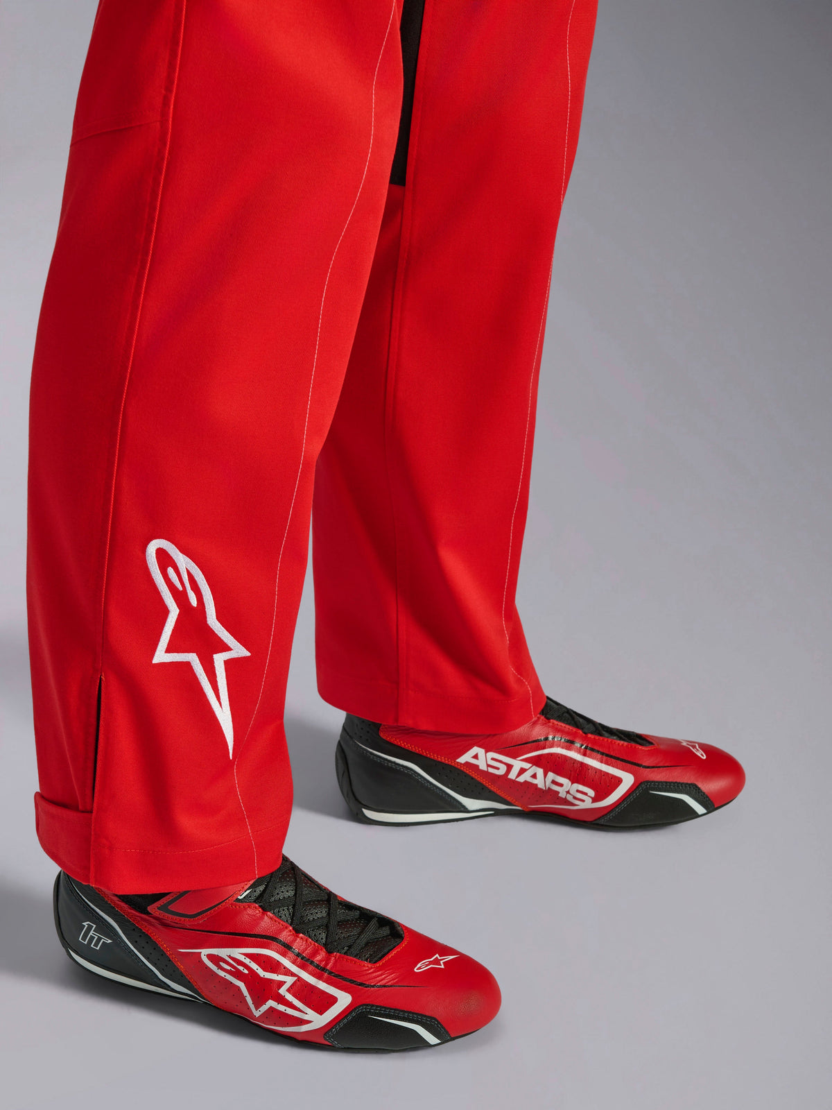 Alpinestars Kart Indoor V2 Anzug, Rot, Unterschenkel-Detail mit weiß gesticktem Stern-Logo, kombiniert mit passenden rot-schwarzen Kartschuhen, einlagiges Poly-Baumwoll-Twill-Material für den Freizeit-Rennsport
